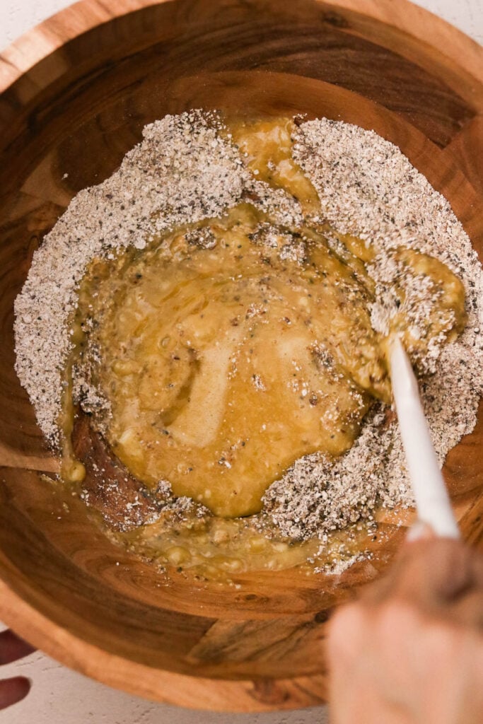 Wet mixture poured into the dry ingredients and gently being mixed together.