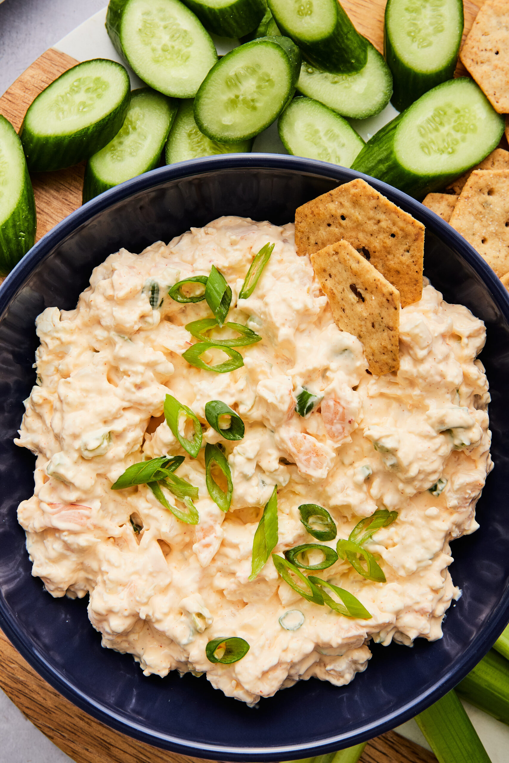Close-up of creamy shrimp dip showing chopped shrimp and celery with a sprinkle of green onions.