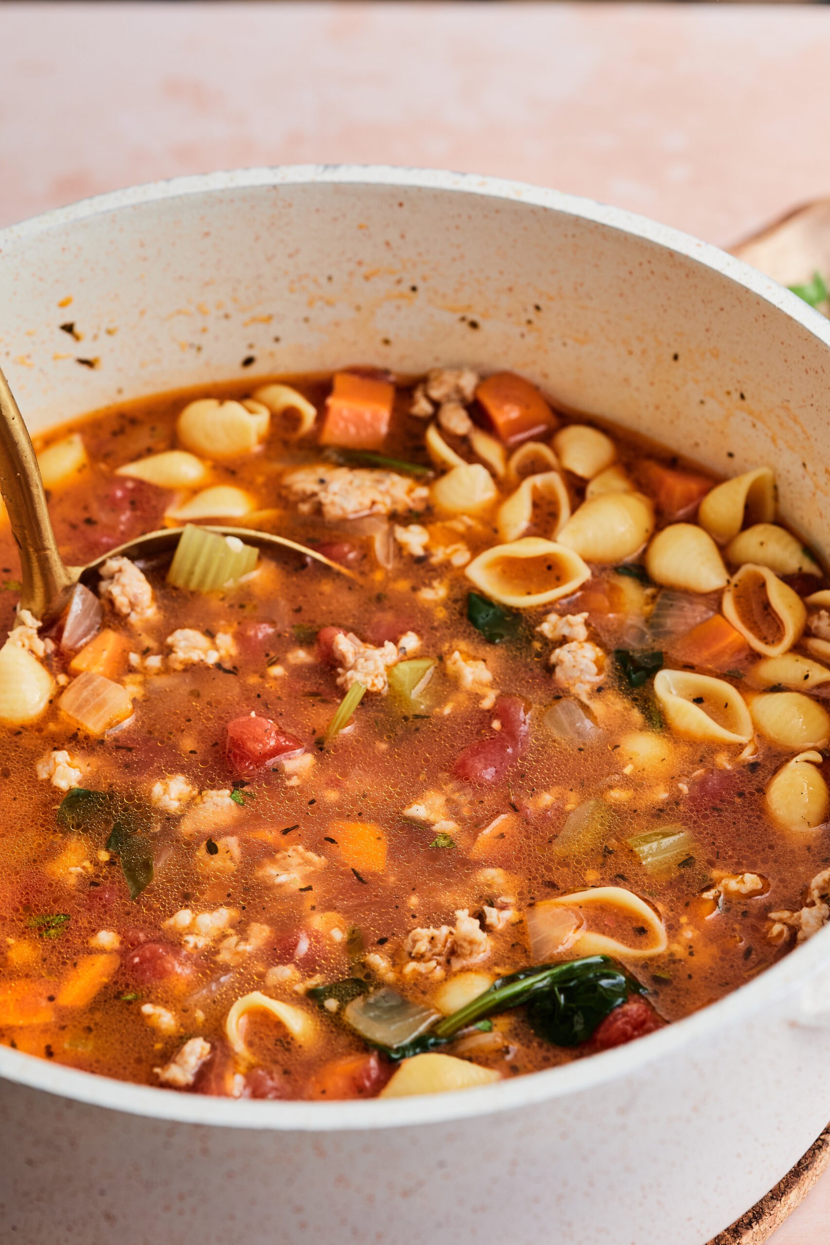 a pot of Italian sausage soup in a white soup pot