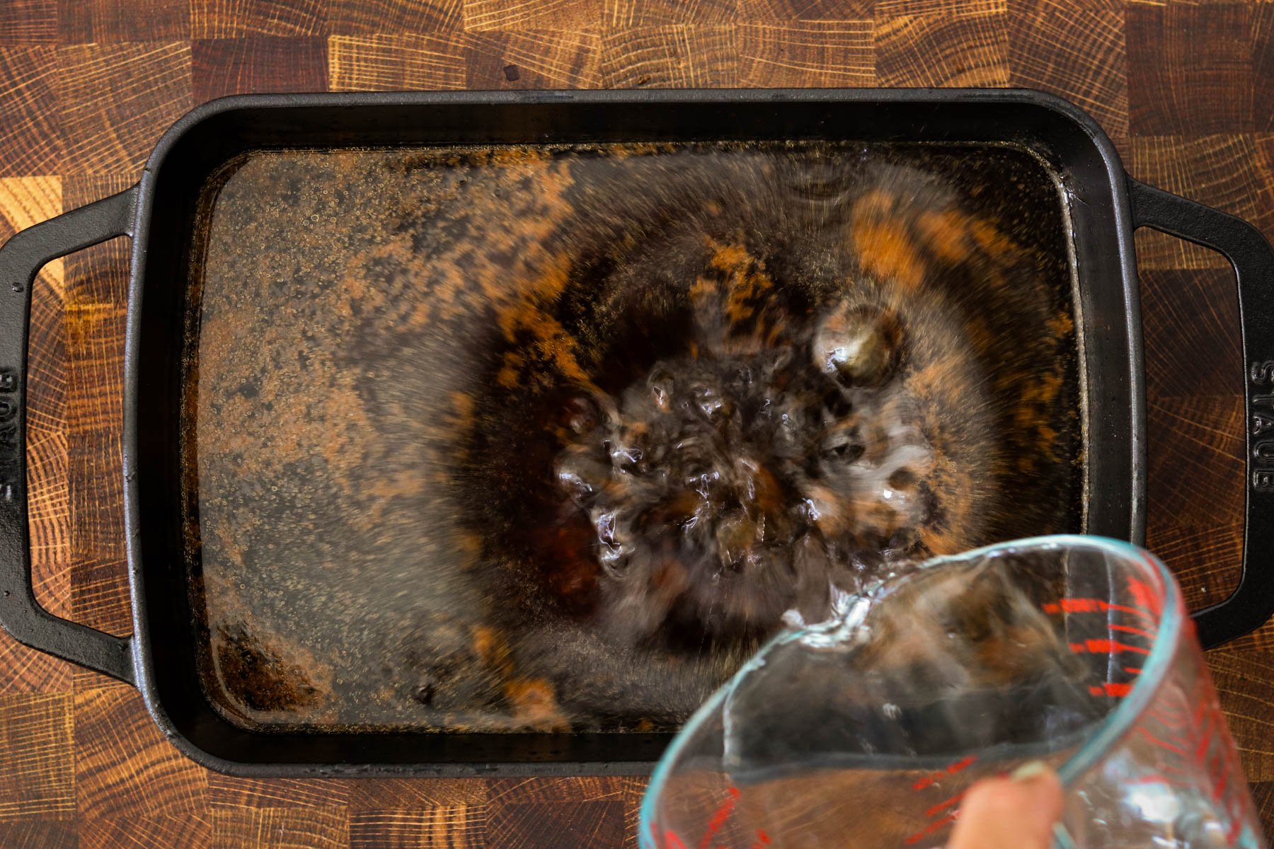 Gochujang, soy sauce, garlic, sugar, sesame oil, and broth ready to whisk together in a baking dish.