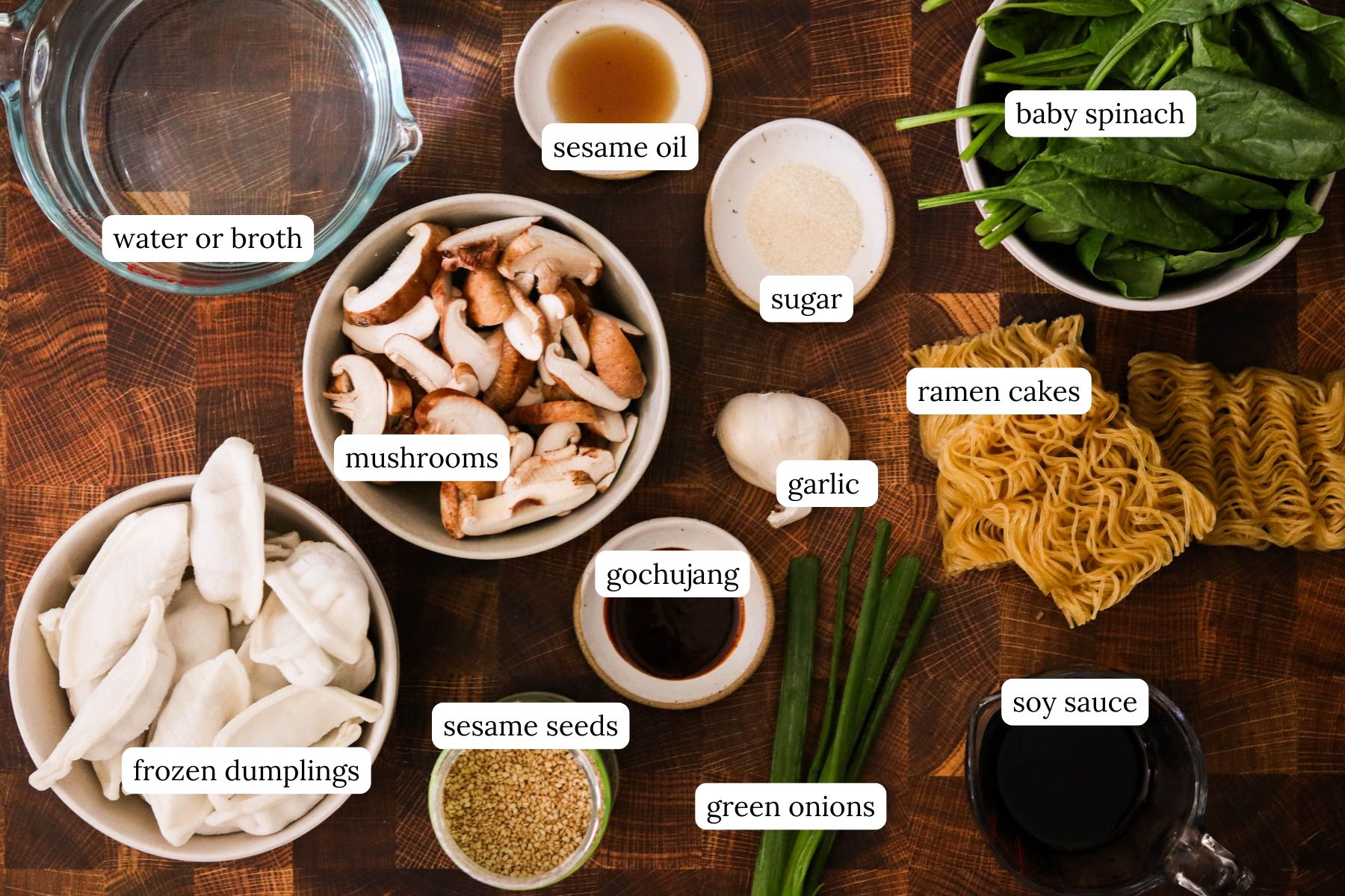 Recipe ingredients for baked dumplings with ramen including gochujang, garlic, soy sauce, sesame oil, mushrooms, spinach, ramen cakes, and frozen dumplings.