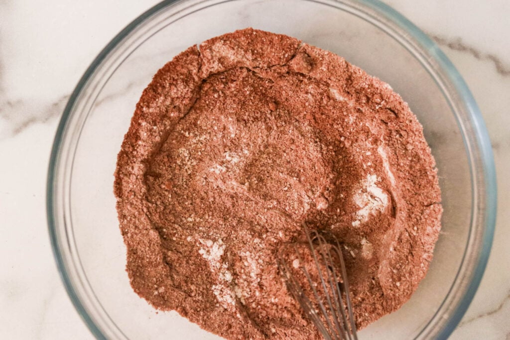 Whisking dry ingredients for cake in a large mixing bowl