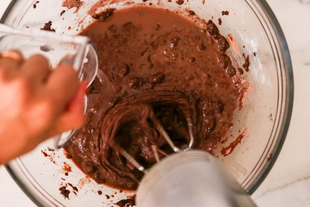 Slowly drizzling in boiled water into the batter