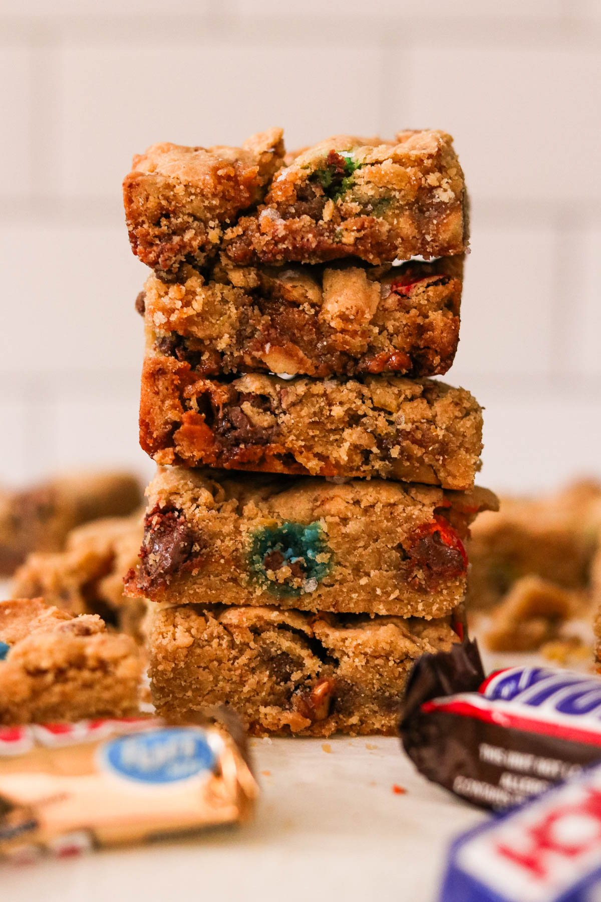 Close-up of leftover Halloween candy cookie bars sliced into squares and stacked on top of one another.