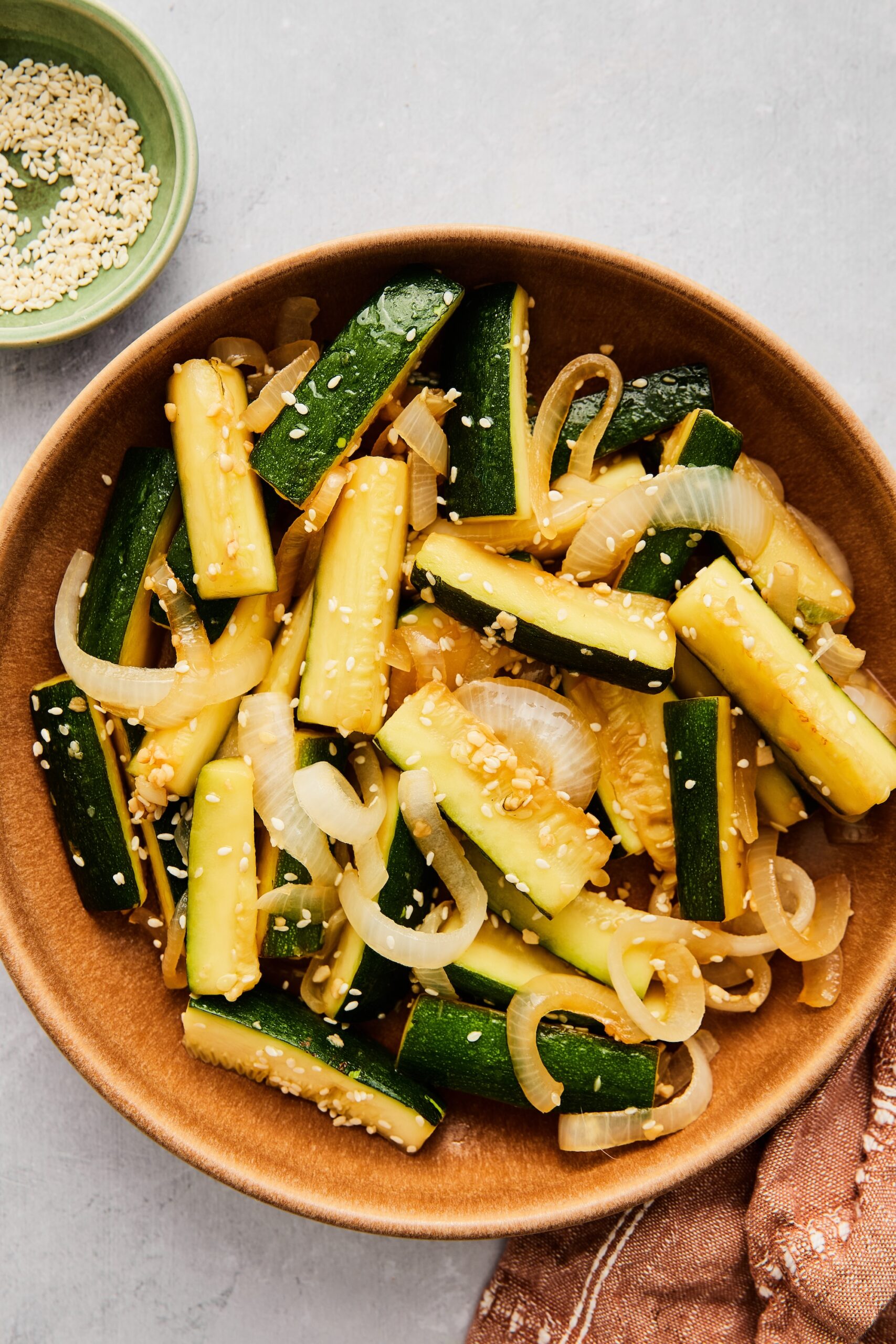 Sautéed Asian zucchini and onions in a serving bowl, ready to eat.
