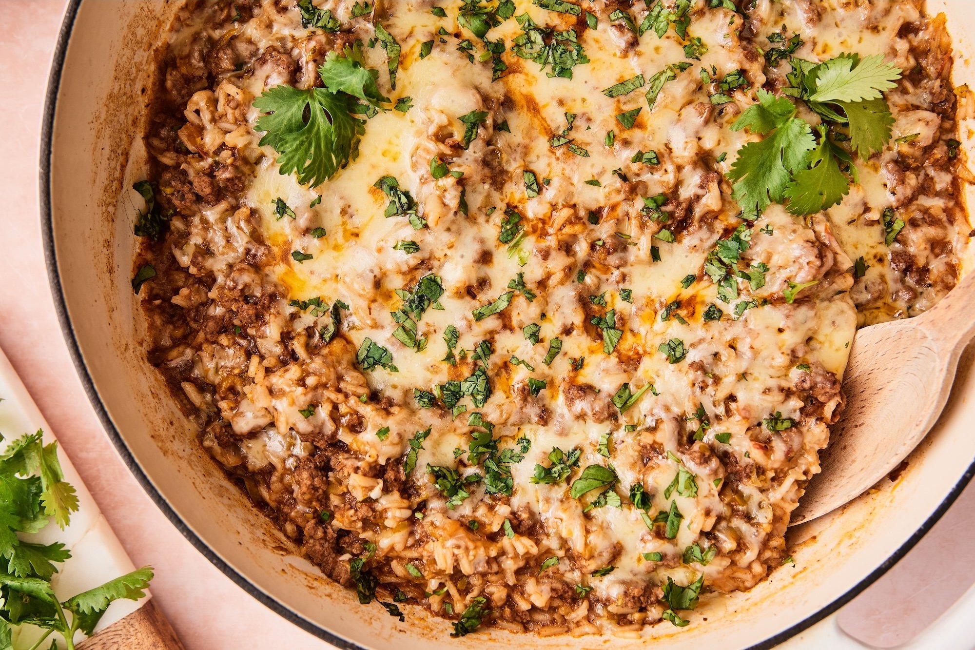 Close-up of ground beef and rice skillet with a spoon lifting out a potion.