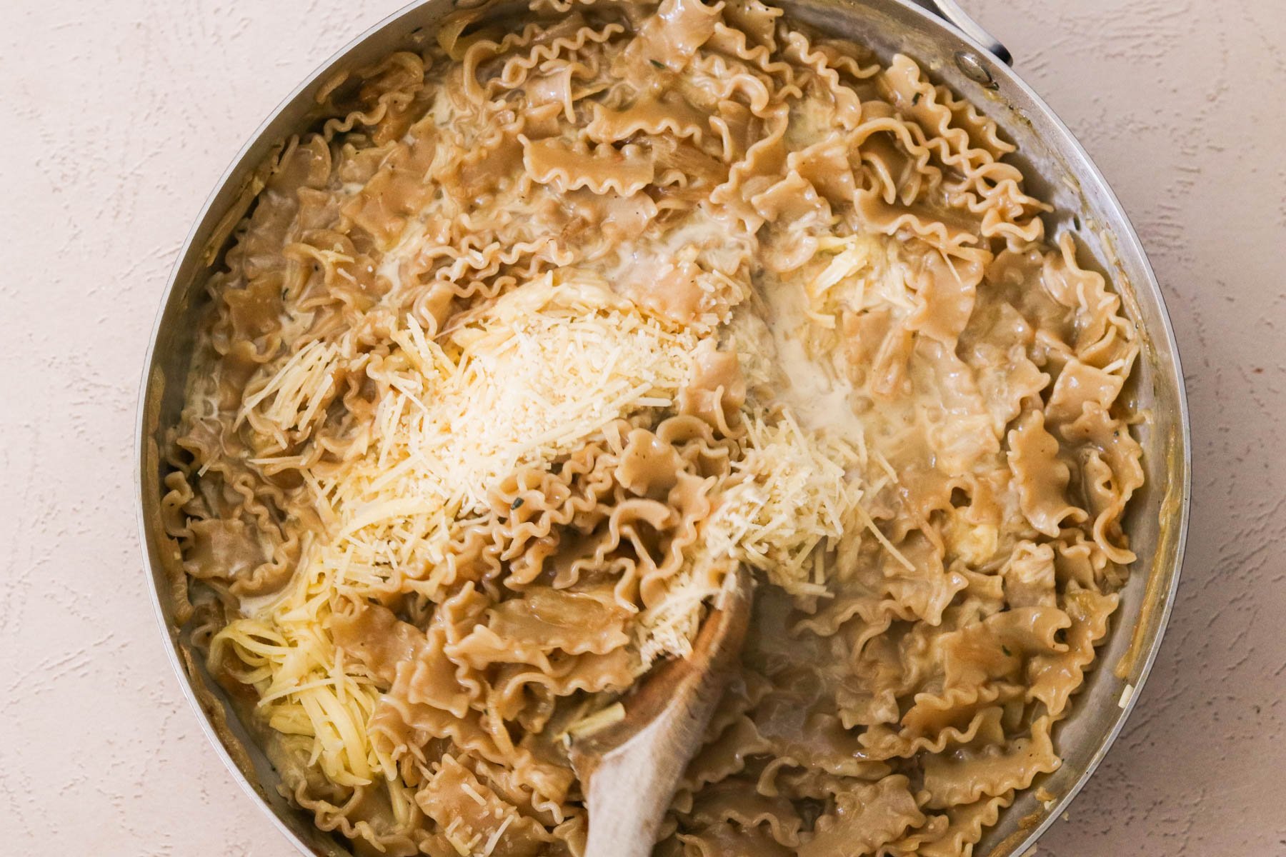 Stirring in cream, smoked gouda, and parmesan to create a silky sauce.