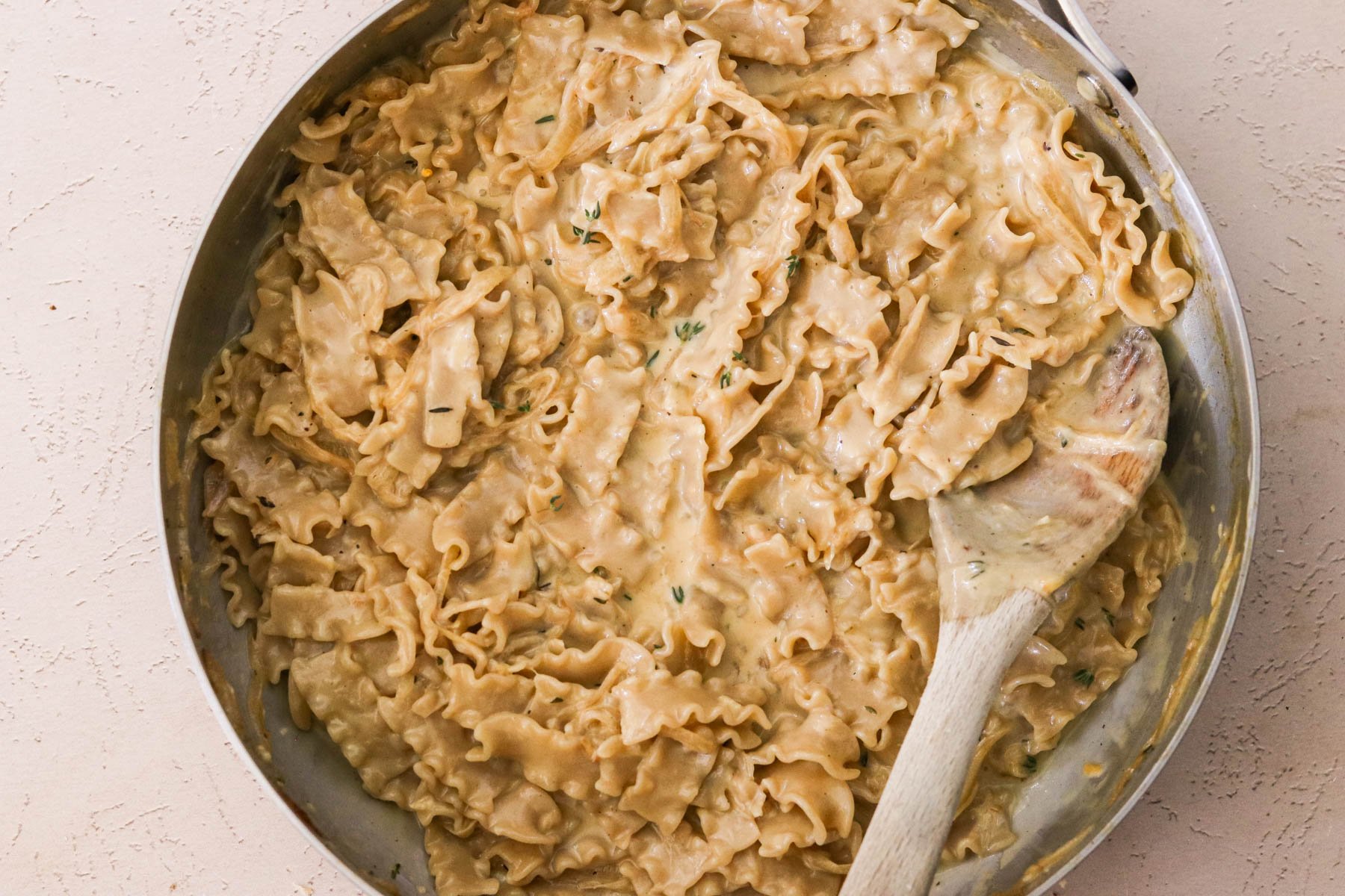 Finished pasta garnished with fresh thyme, ready to serve.