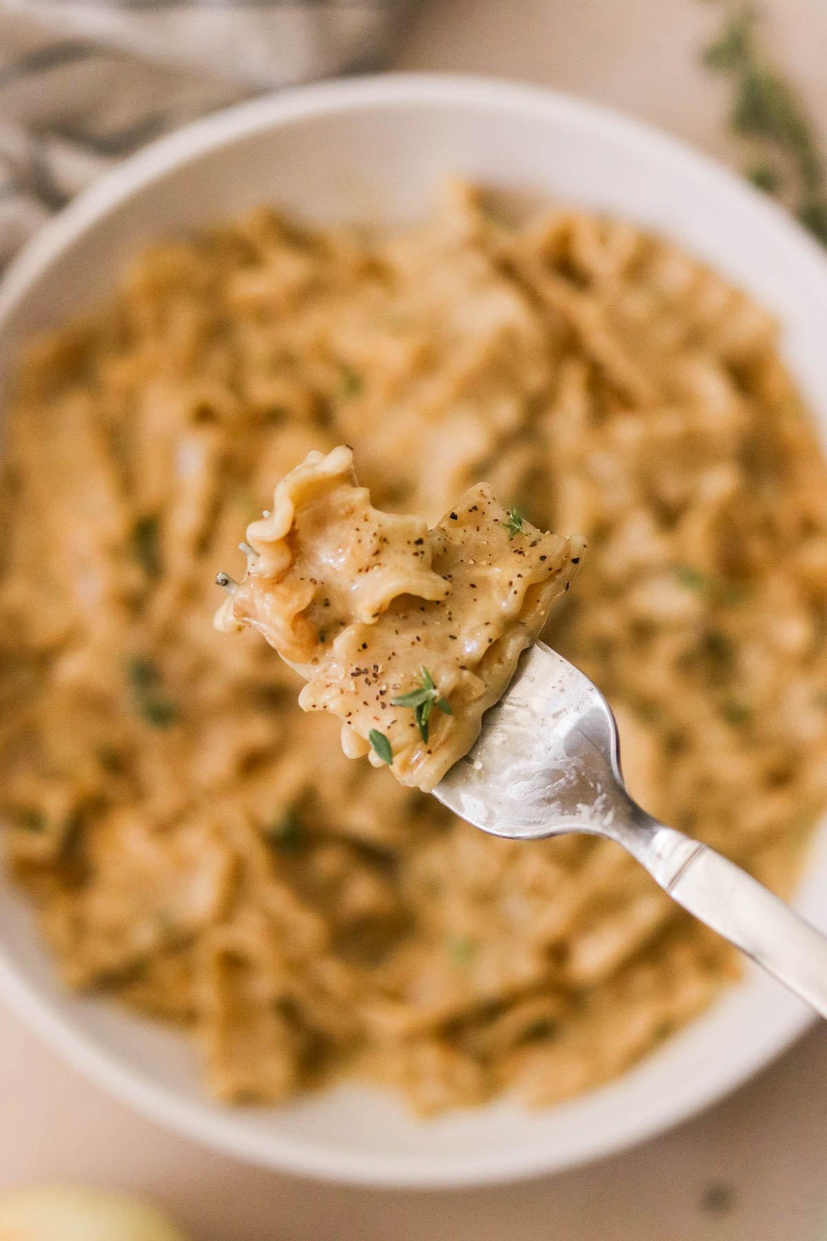 French onion pasta on a fork, ready to eat.