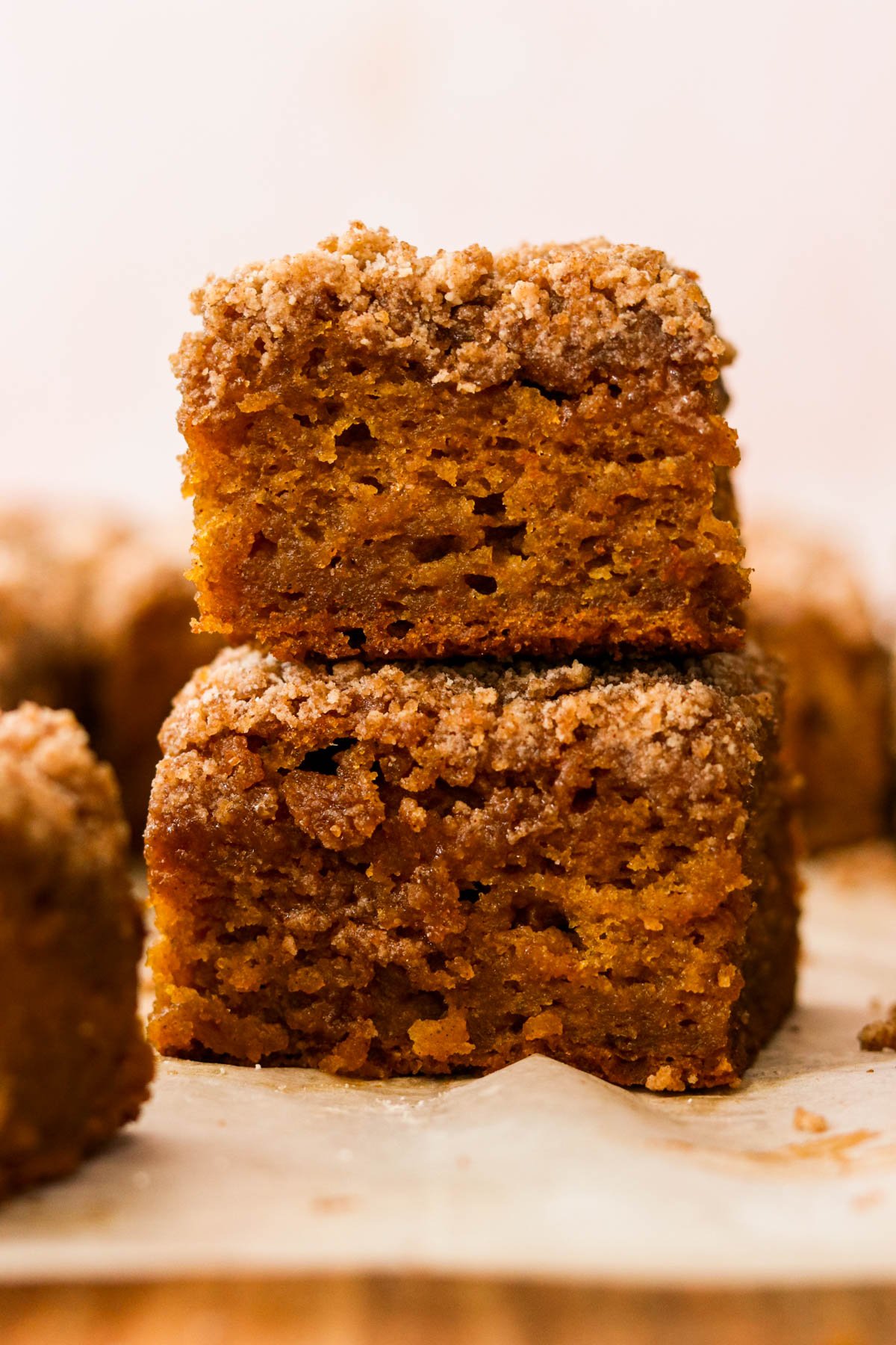 Close-up of two slices of gluten-free pumpkin coffee cake with thick cinnamon crumb topping, stacked on top of each other.