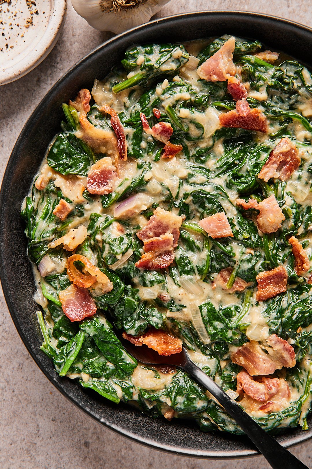 Close-up of keto creamed spinach in a black serving bowl.