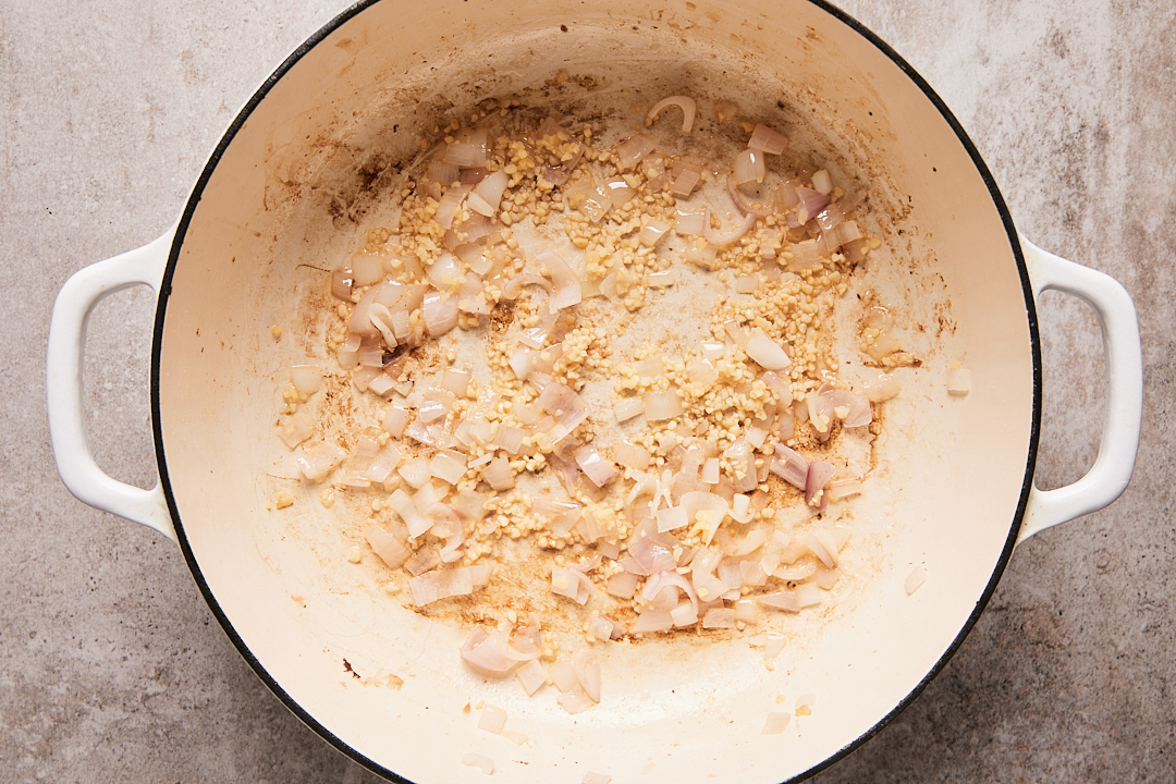 Reserved bacon fat in a Dutch oven with shallot and garlic.