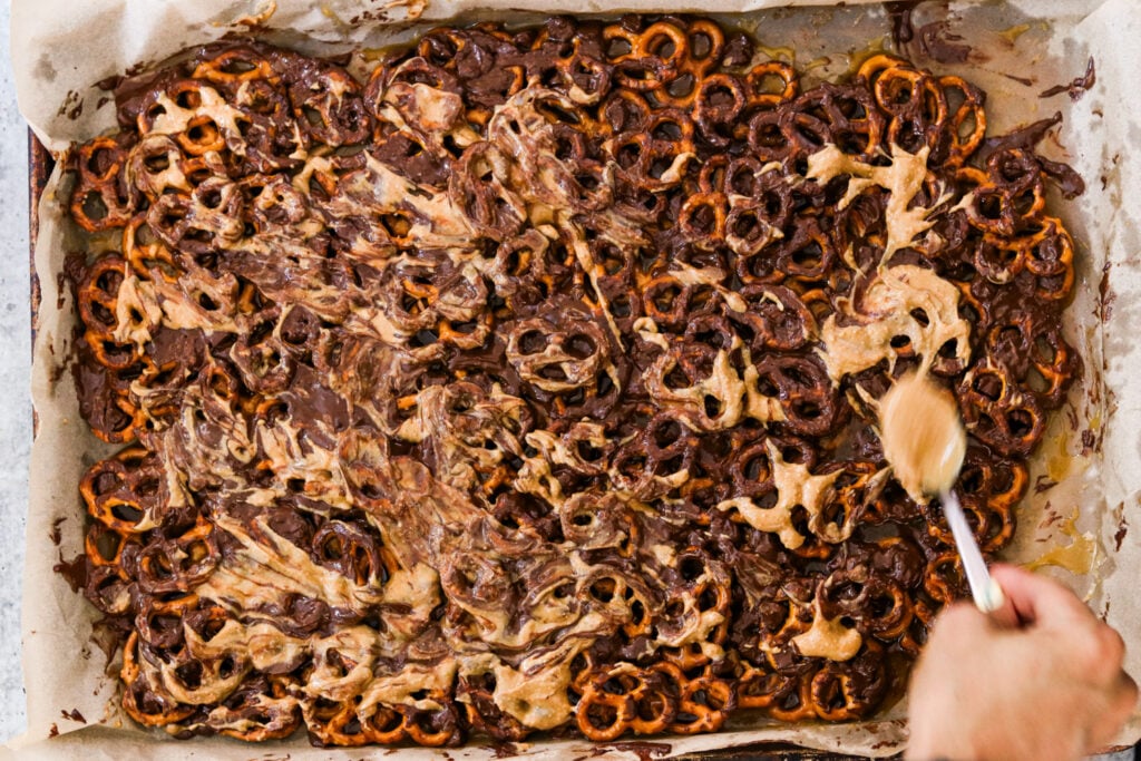swirling chocolate and peanut butter atop the christmas crack with pretzels 