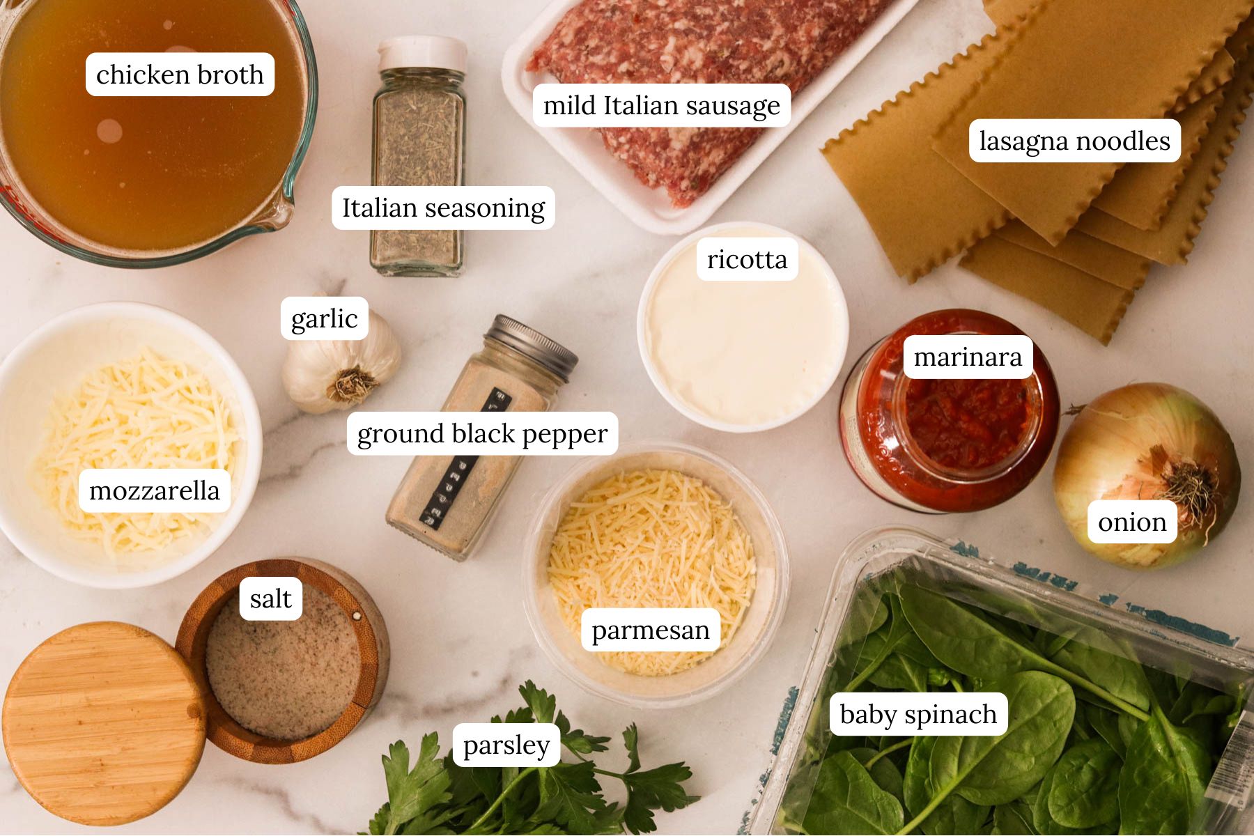 Ingredients for instant pot lasagna soup labeled and laid out on a white countertop.