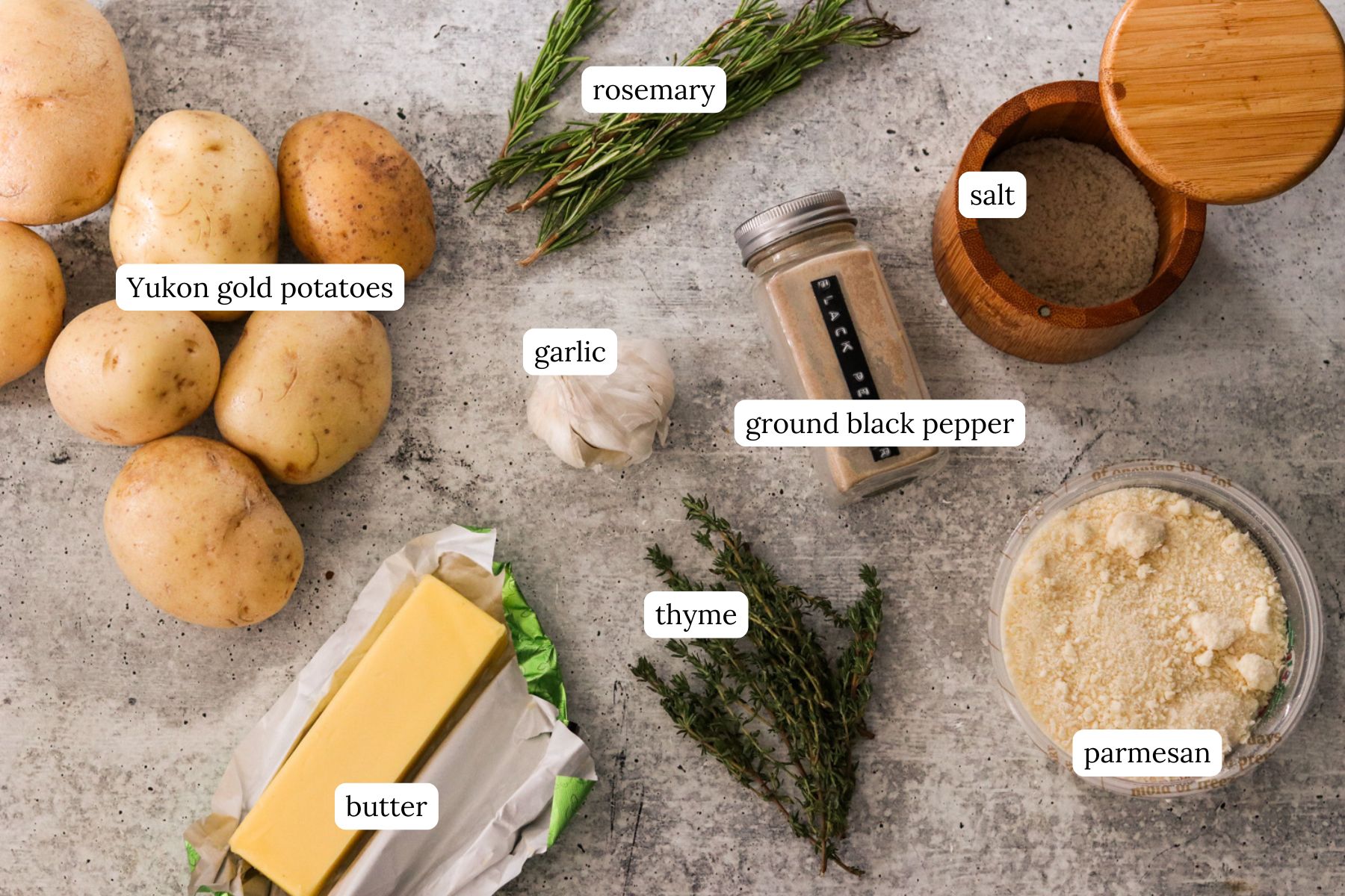 Ingredients for crispy stacked potatoes labeled and laid out on a gray countertop. 