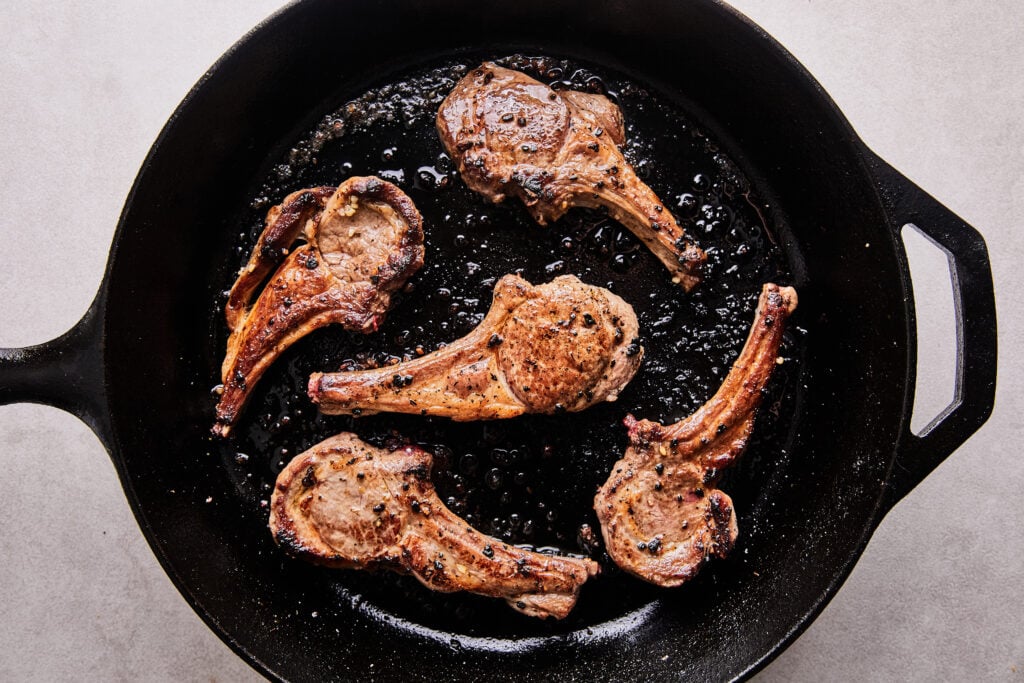 frying lamb chops in a cast iron skillet in coconut oil