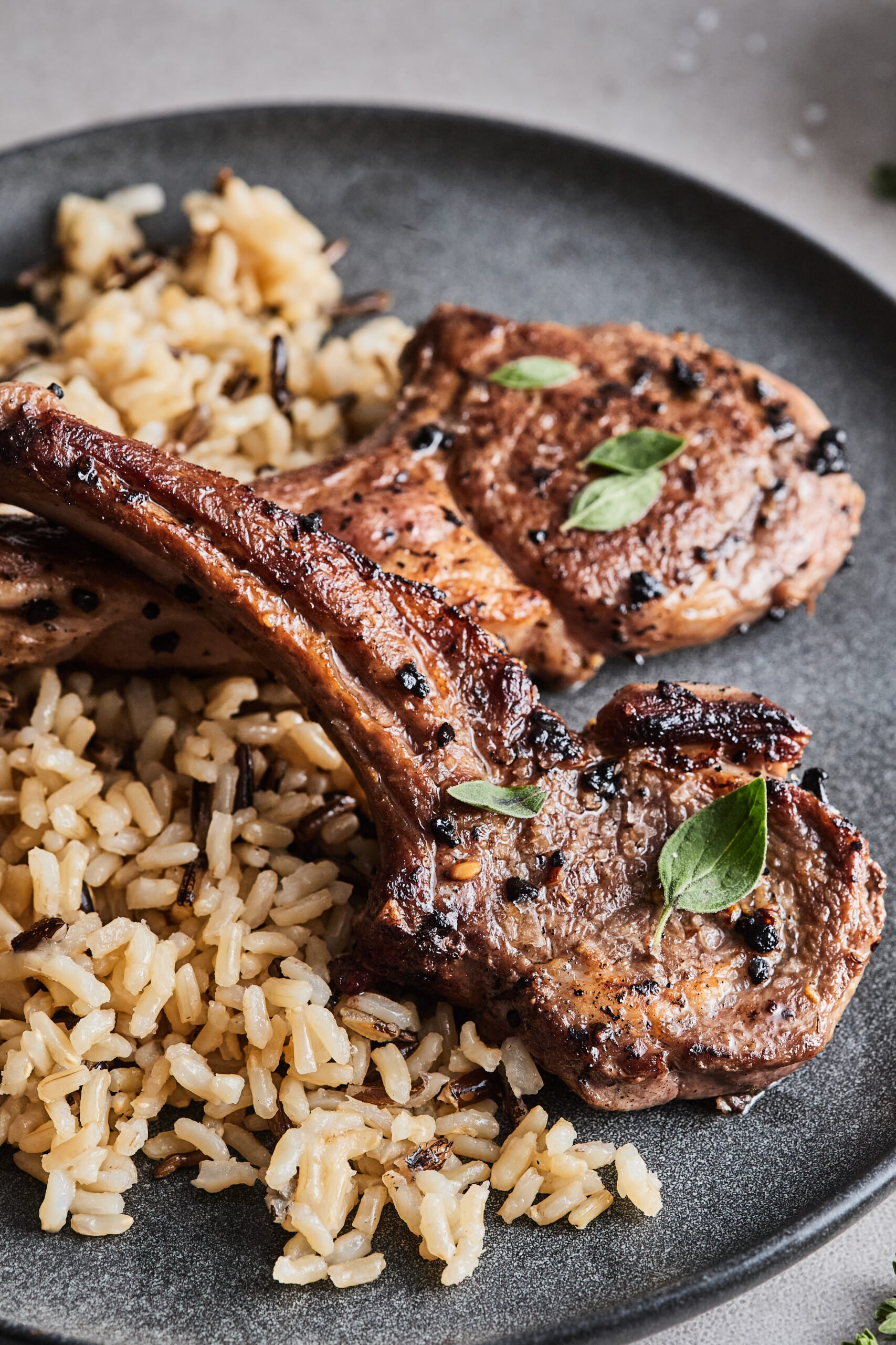 a plate of pan seared lamb chops with rice