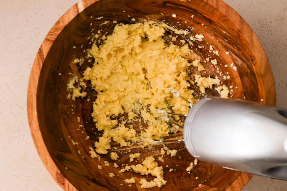 Butter and sugar being creamed in a large bowl.