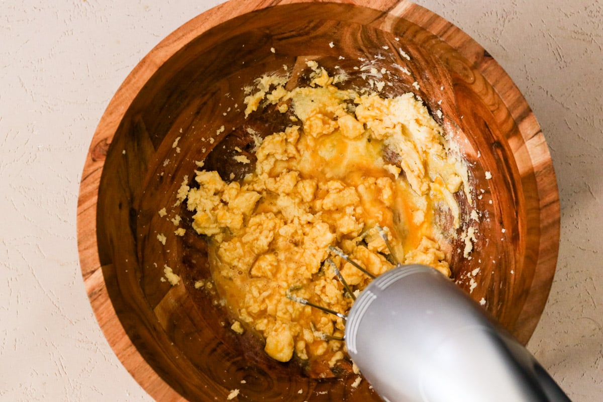 Egg and vanilla added to the creamed butter and sugar; being mixed until fully combined.