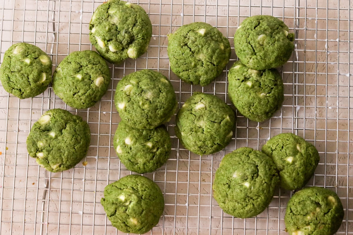 Baked matcha chocolate chip cookies on a cooling rack.