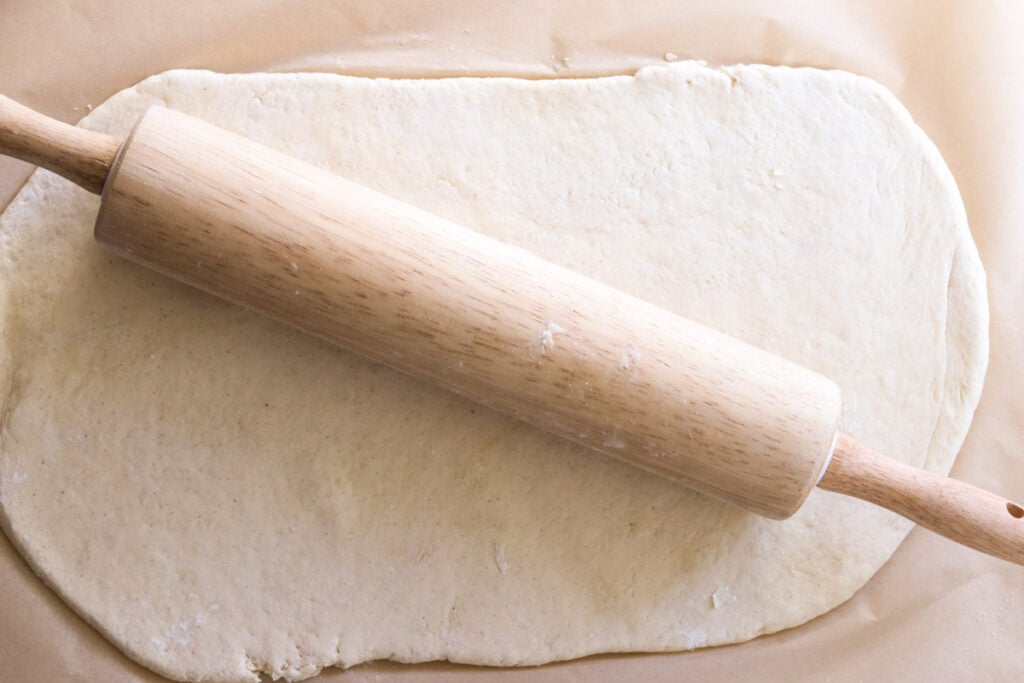 a rolling pin resting on top of a rolled out dough rectangle.