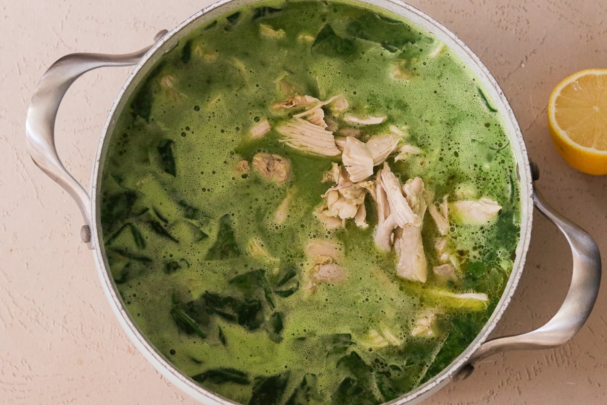 Blended green soup added back into a large soup pot along with shredded chicken.