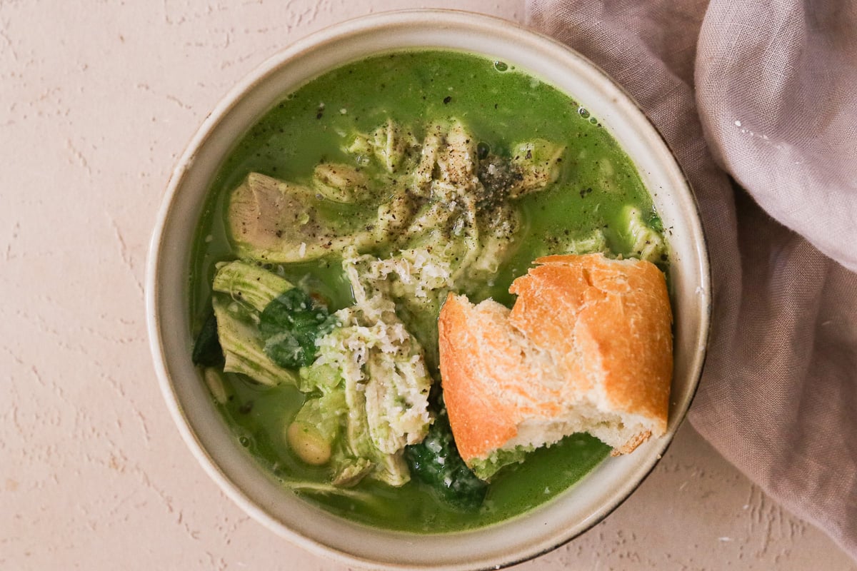 Creamy chicken and white bean soup served with crusty bread in a bowl.