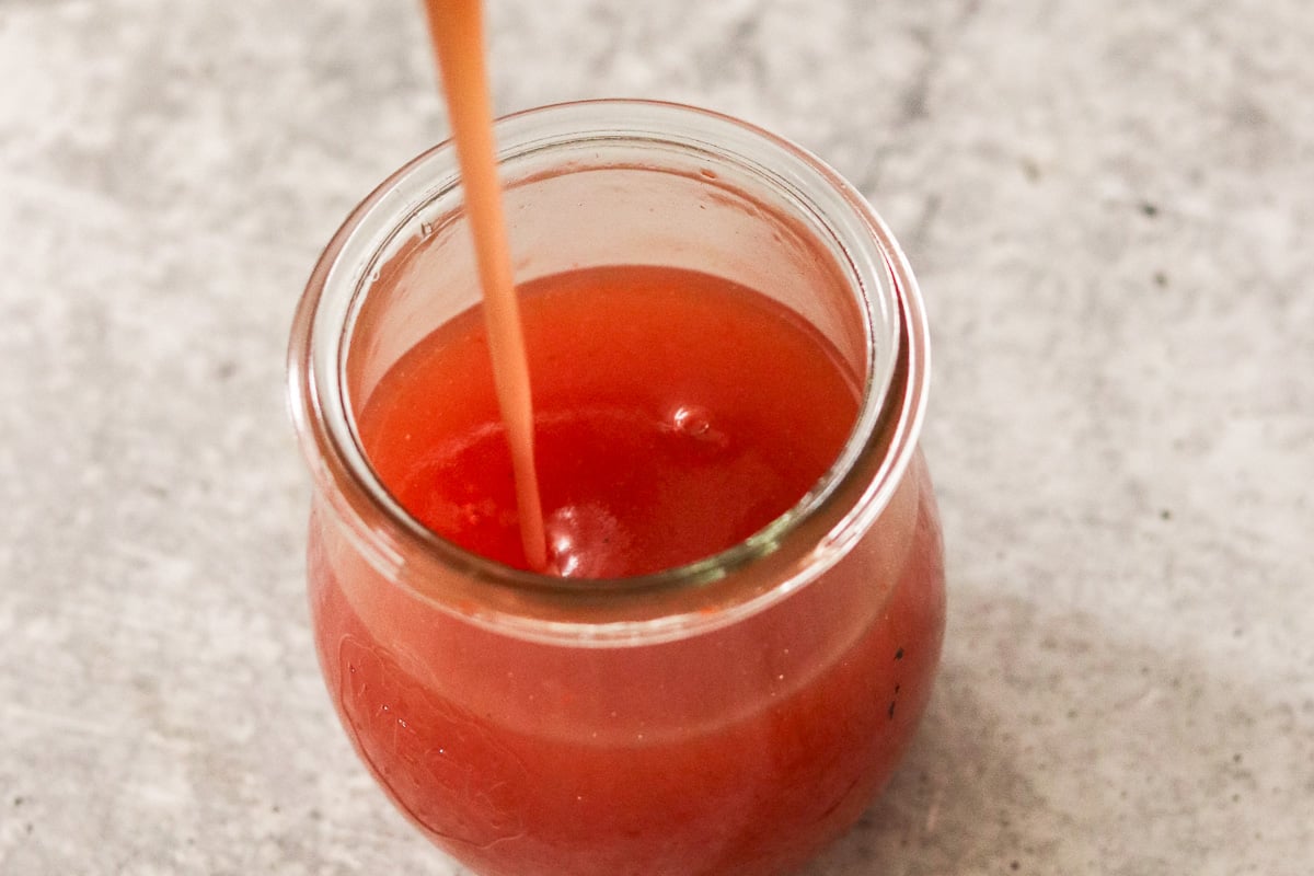 Glass jar with homemade sweet and sour sauce.