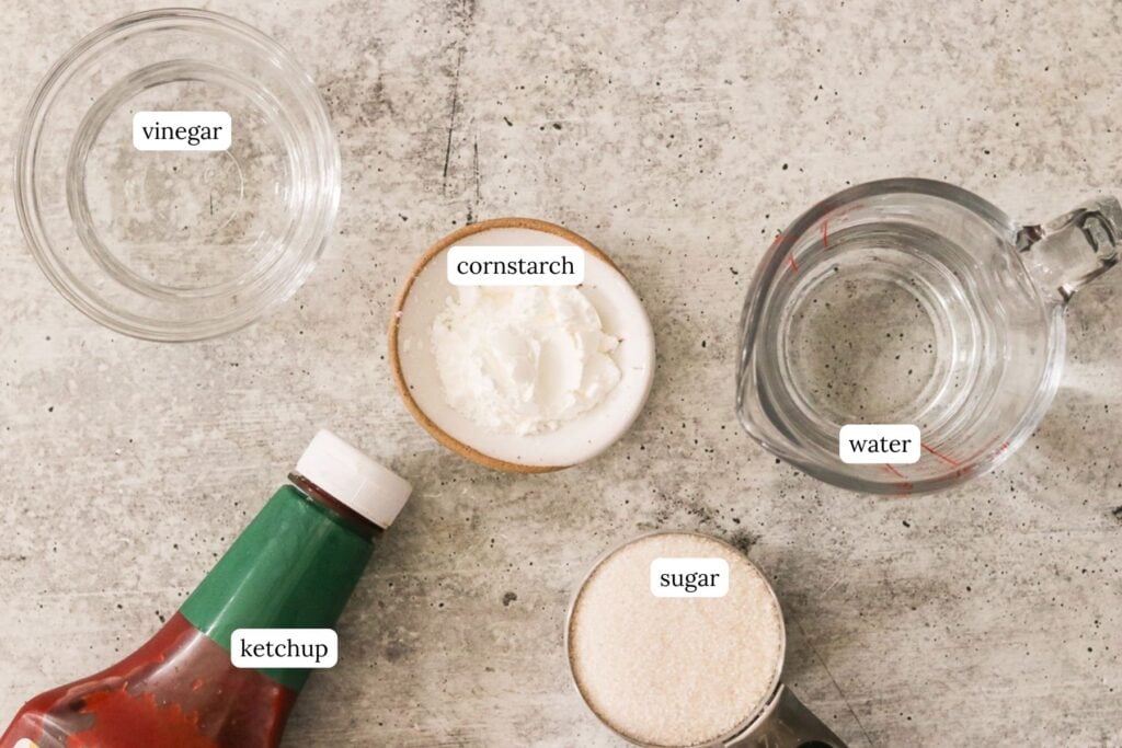 Labeled ingredients for homemade sweet and sour sauce arranged on a gray countertop.