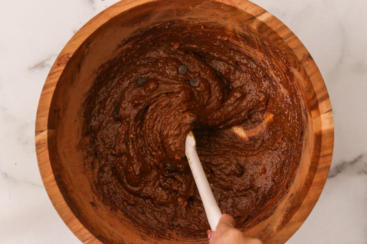 Chocolate chips being folded into the sweet potato brownie batter.
