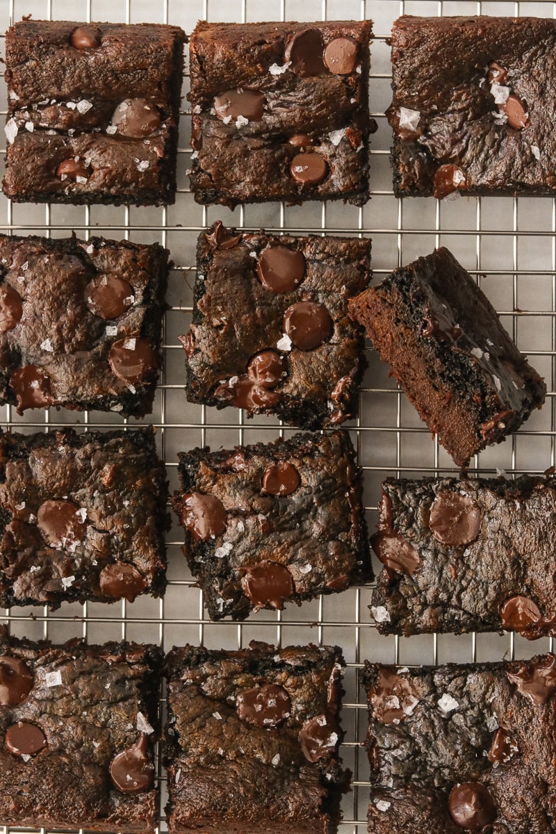 Sweet potato brownies on a wire cooling rack, topped with flaky sea salt.