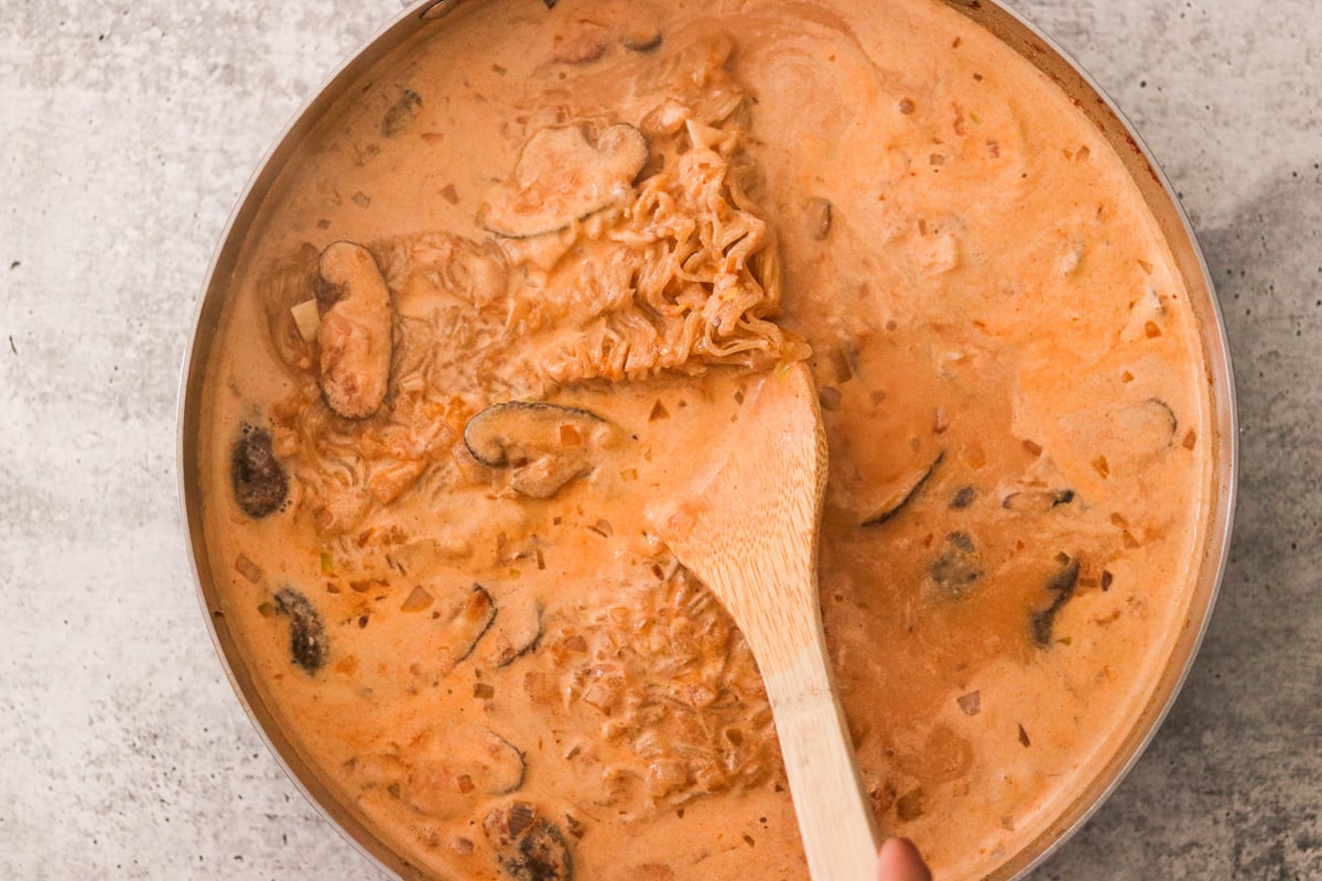 Gluten-free ramen noodles simmering in coconut curry broth.