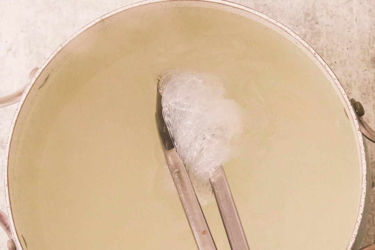 Vermicelli noodles cooking in a large pot.