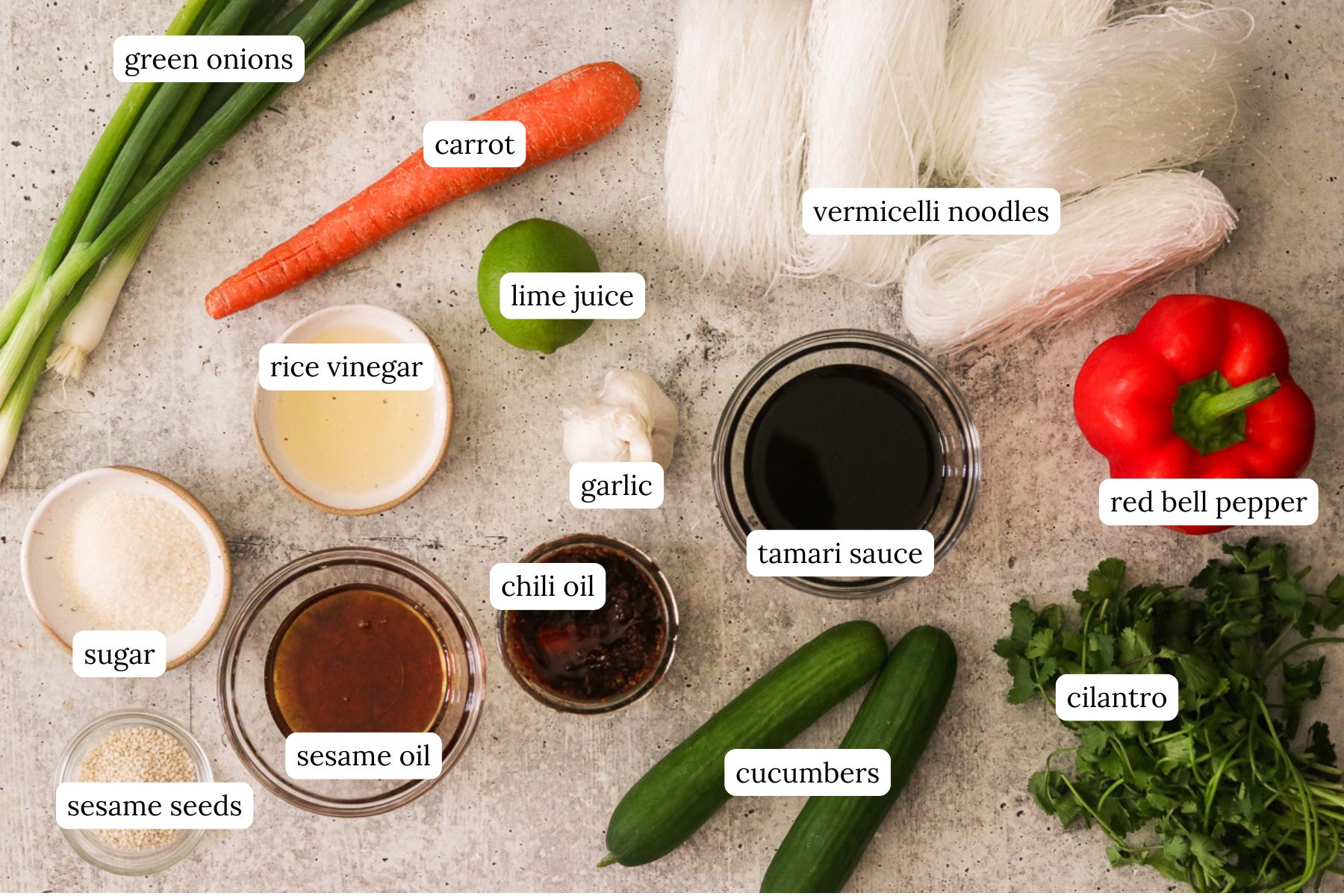 Sesame noodle salad recipe ingredients laid out and labeled on a countertop.