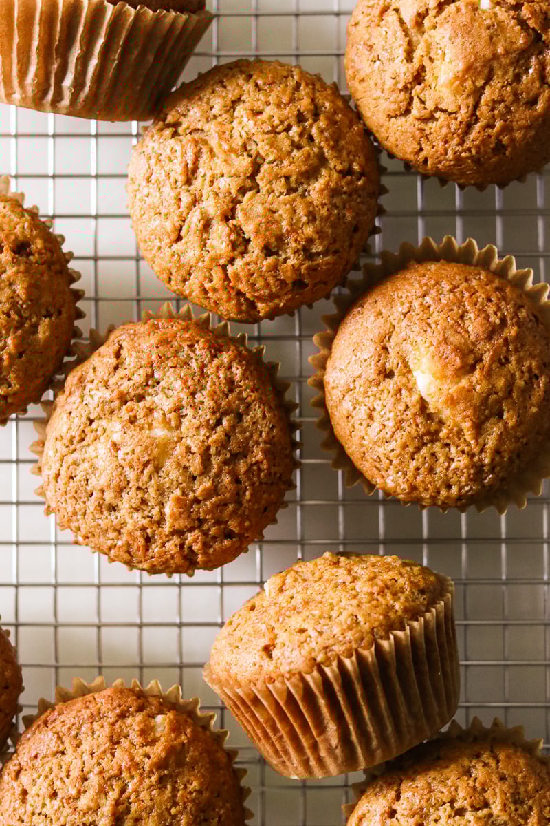 Overhead shot of gluten-free carrot cake muffins on a wire cooling rack.