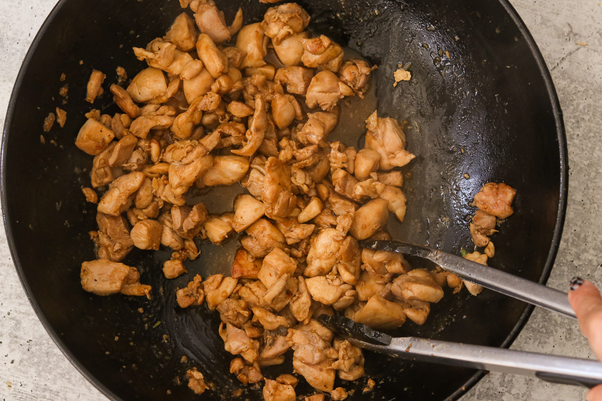 Marinated chicken cooking in a skillet.