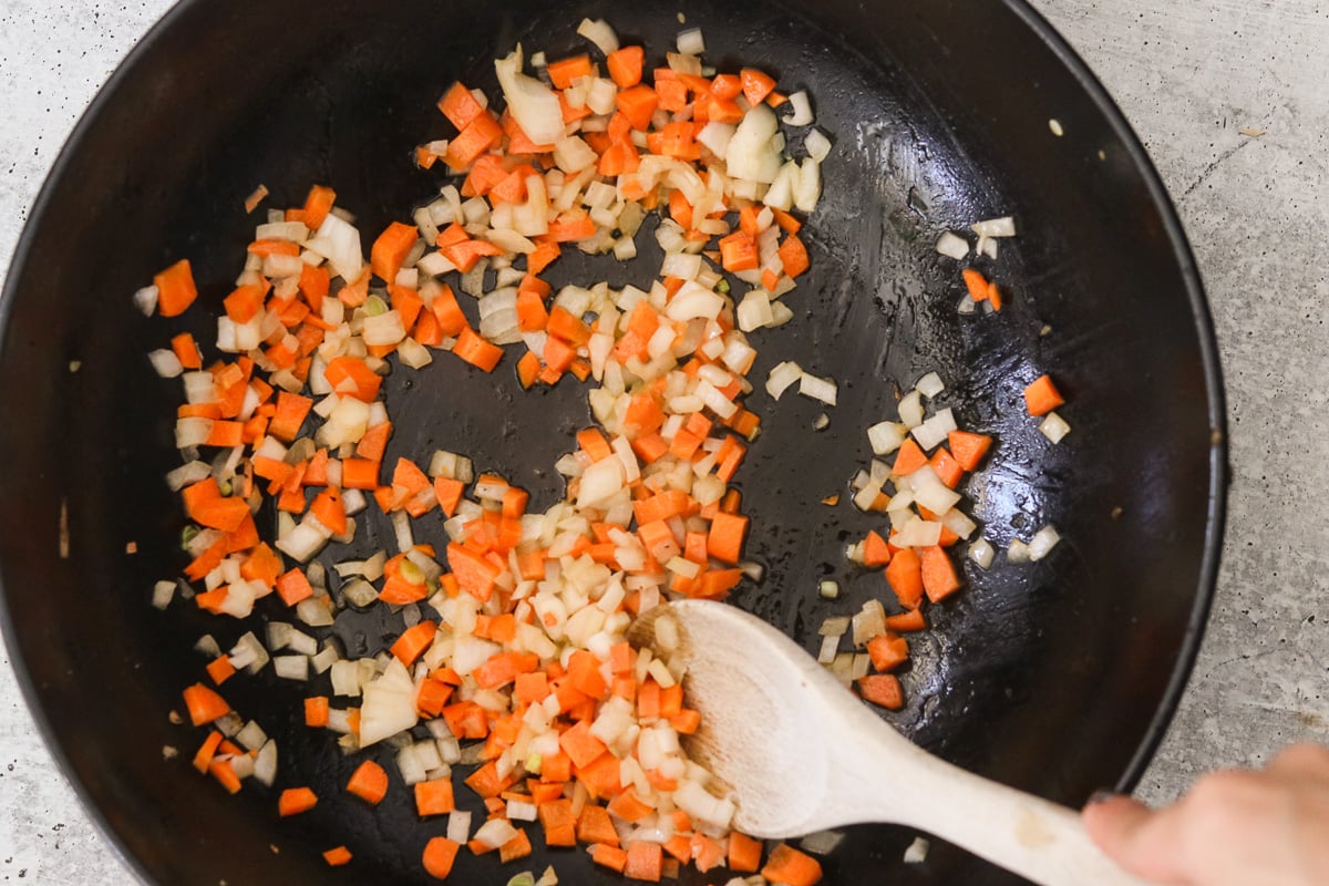 Diced carrots and onion sautéing in melted butter in the same skillet.