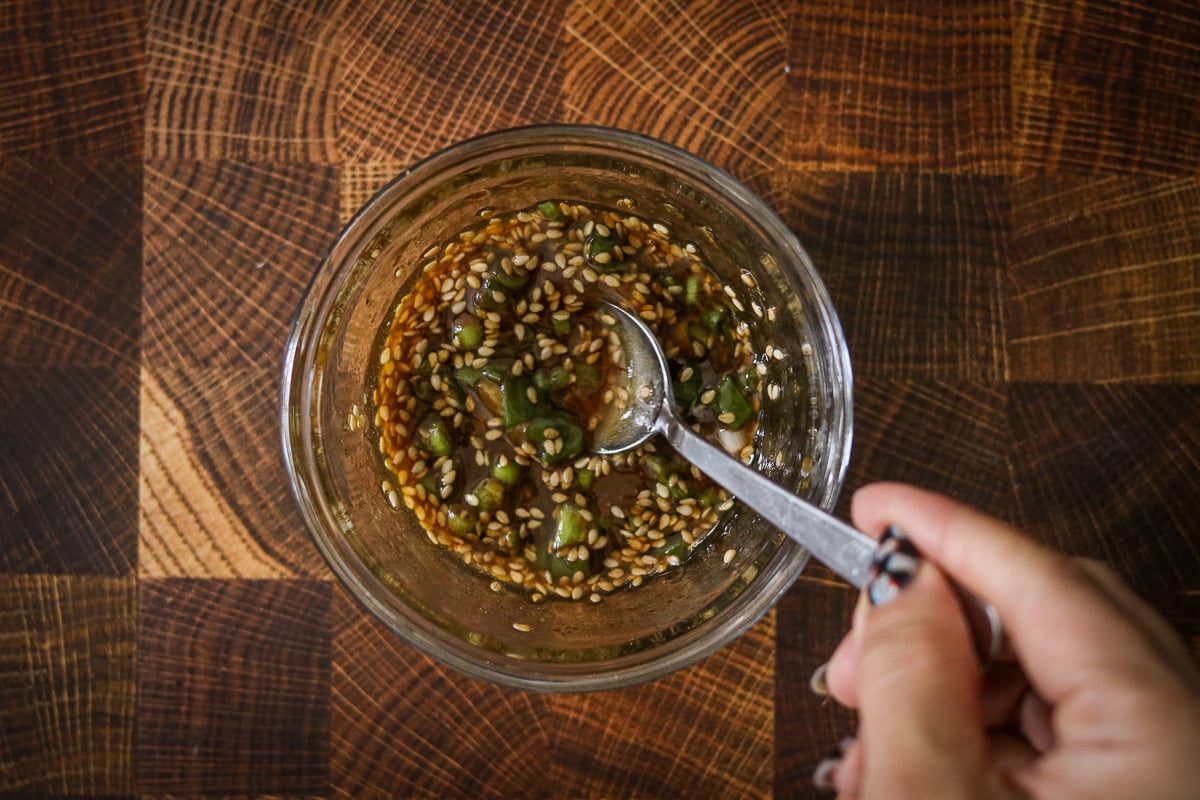 Dipping sauce ingredients being stirred together with a spoon in a small bowl.