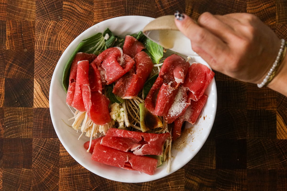 Tamari, sesame oil, and mirin drizzled over ingredients with sugar and garlic sprinkled on top.