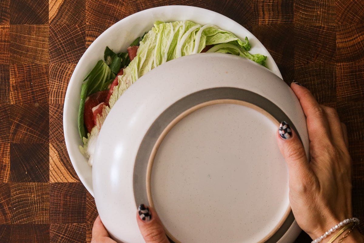 A large plate placed over a bowl to cover microwave hot pot before cooking.