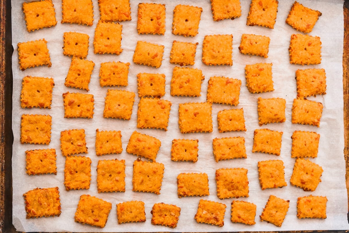 Freshly baked sweet potato crackers on a parchment lined baking sheet.