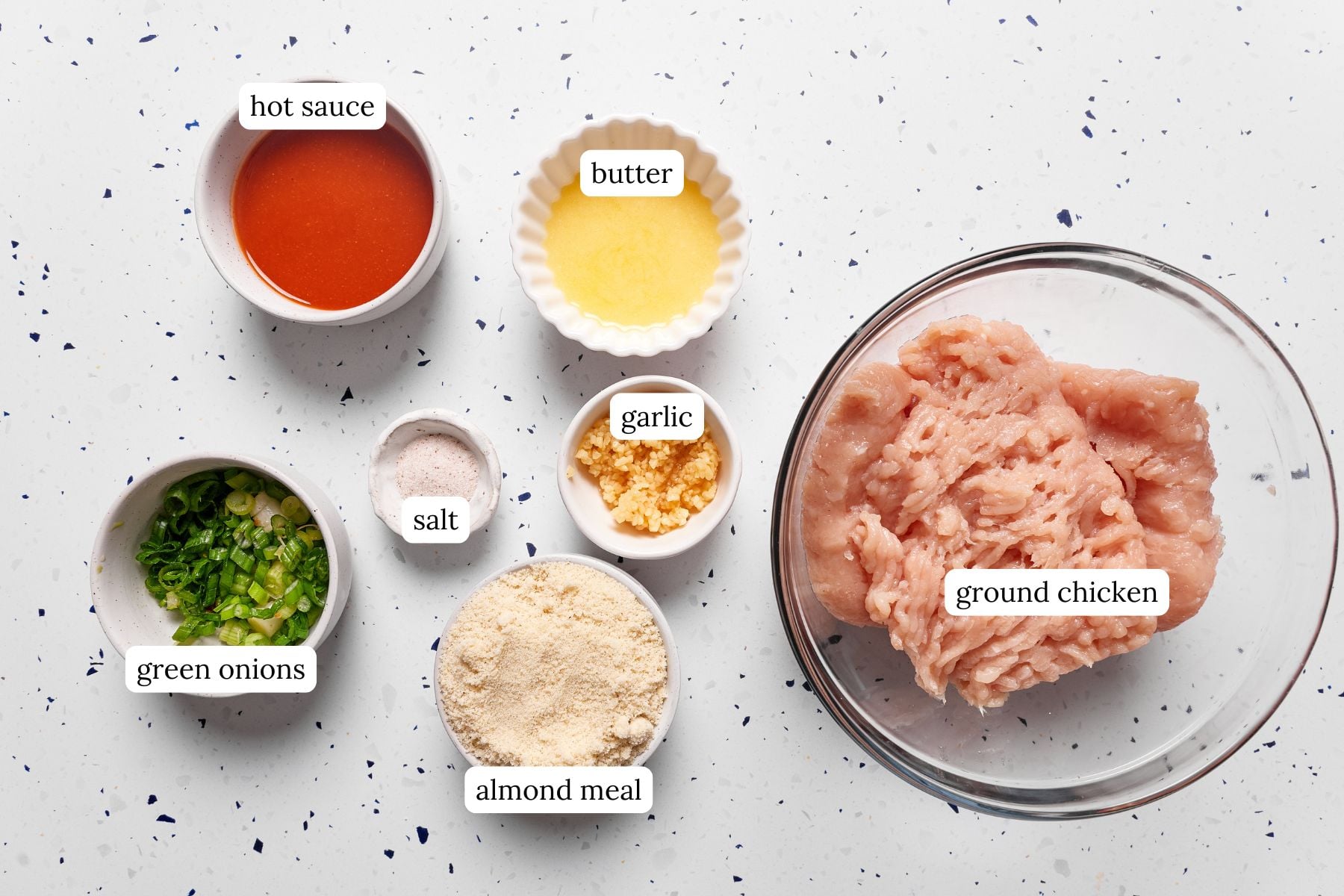 Buffalo chicken meatball recipe ingredients laid out and labeled on a countertop.