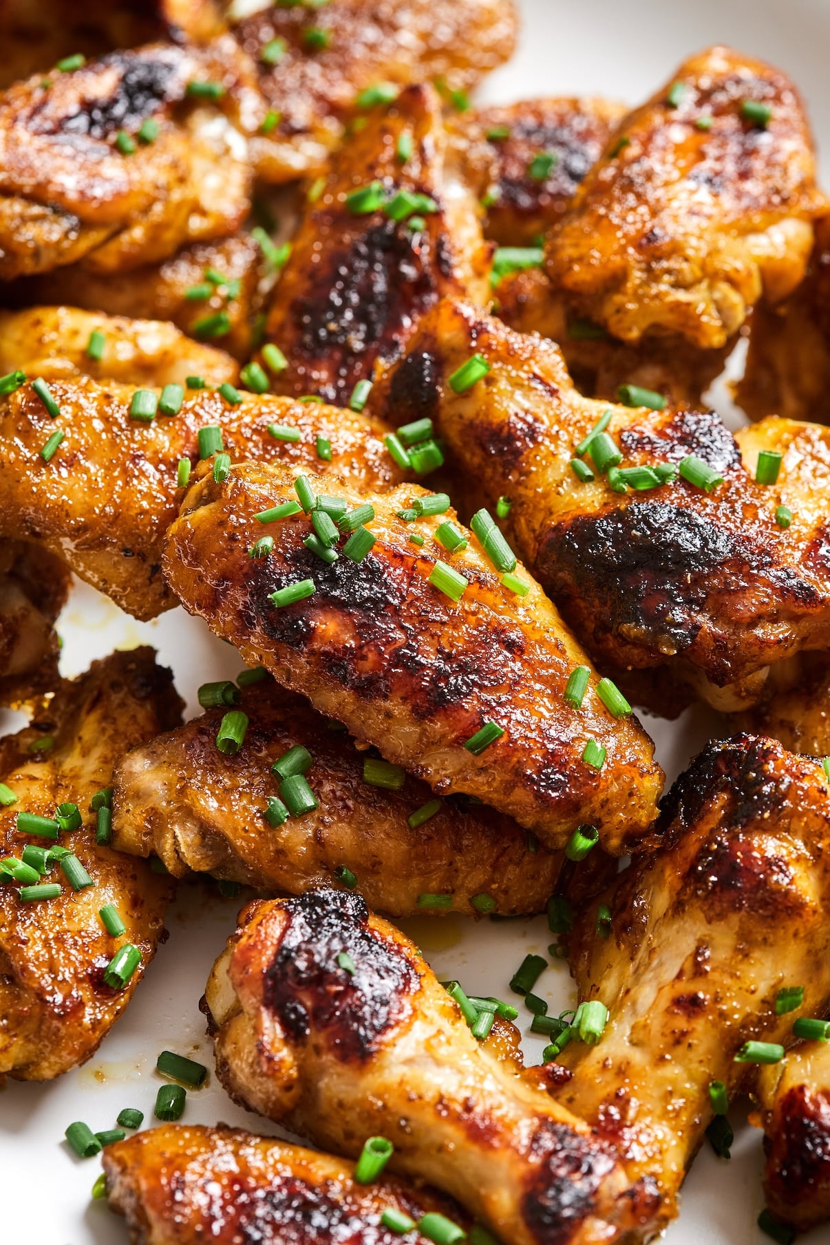 Close-up of crispy paleo chicken wings garnished with chopped chives.