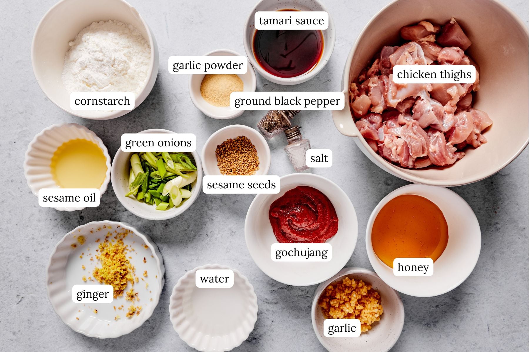 Gochujang chicken recipe ingredients laid out and labeled in bowls.