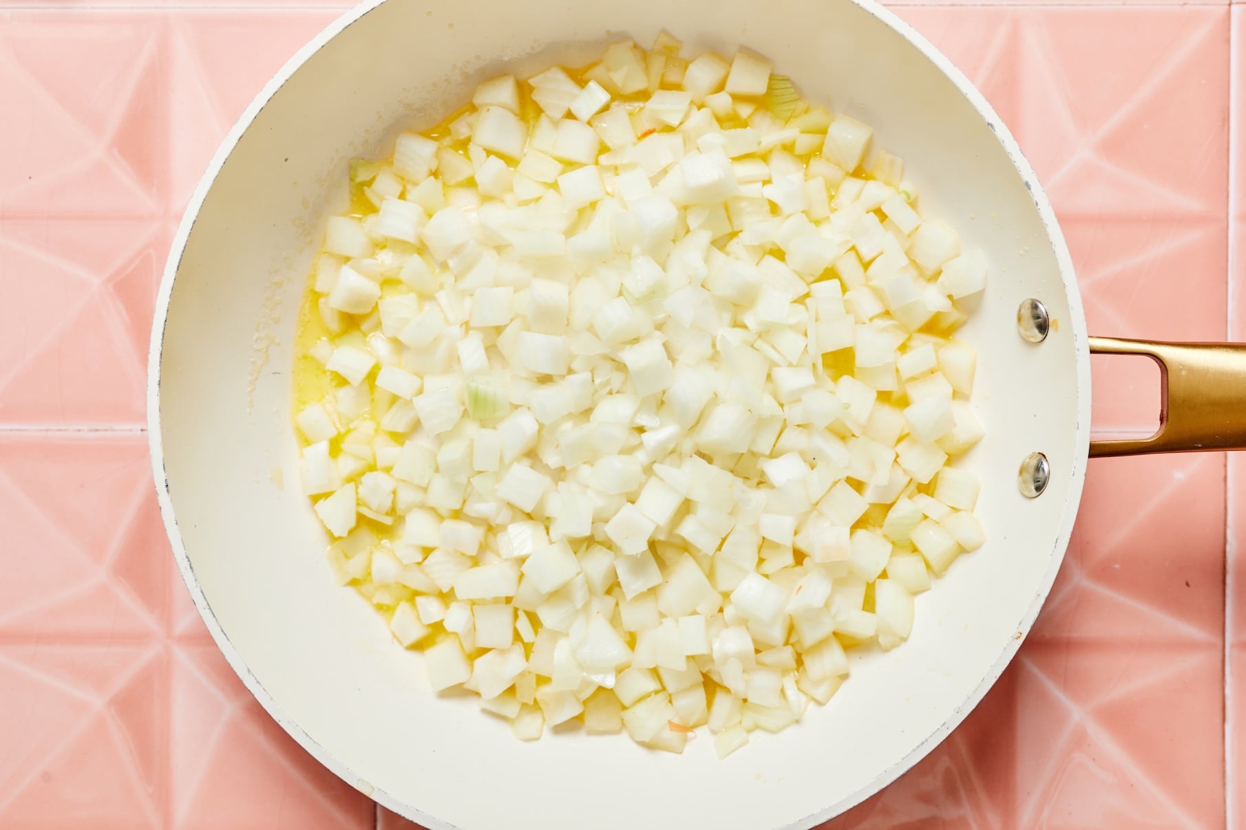 Chopped onions cooking in melted butter in a skillet.