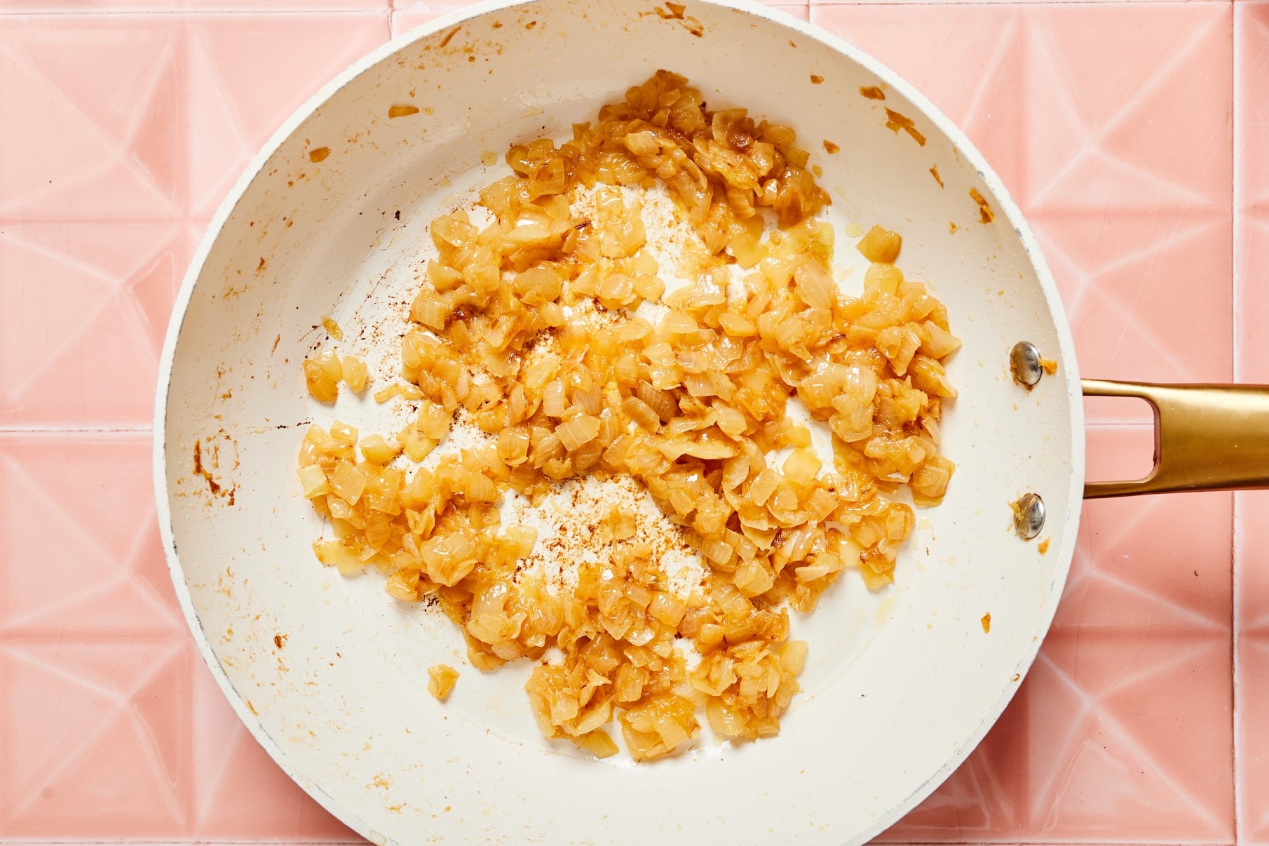 Golden brown caramelized onions cooking in a skillet.