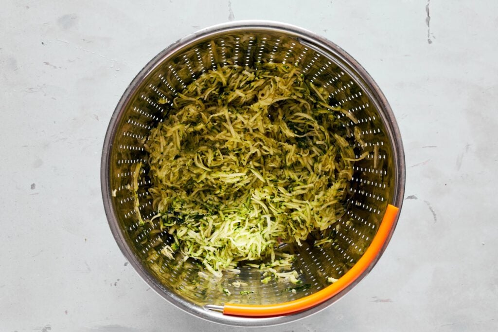 Grated zucchini with sea salt tossed in a colander.