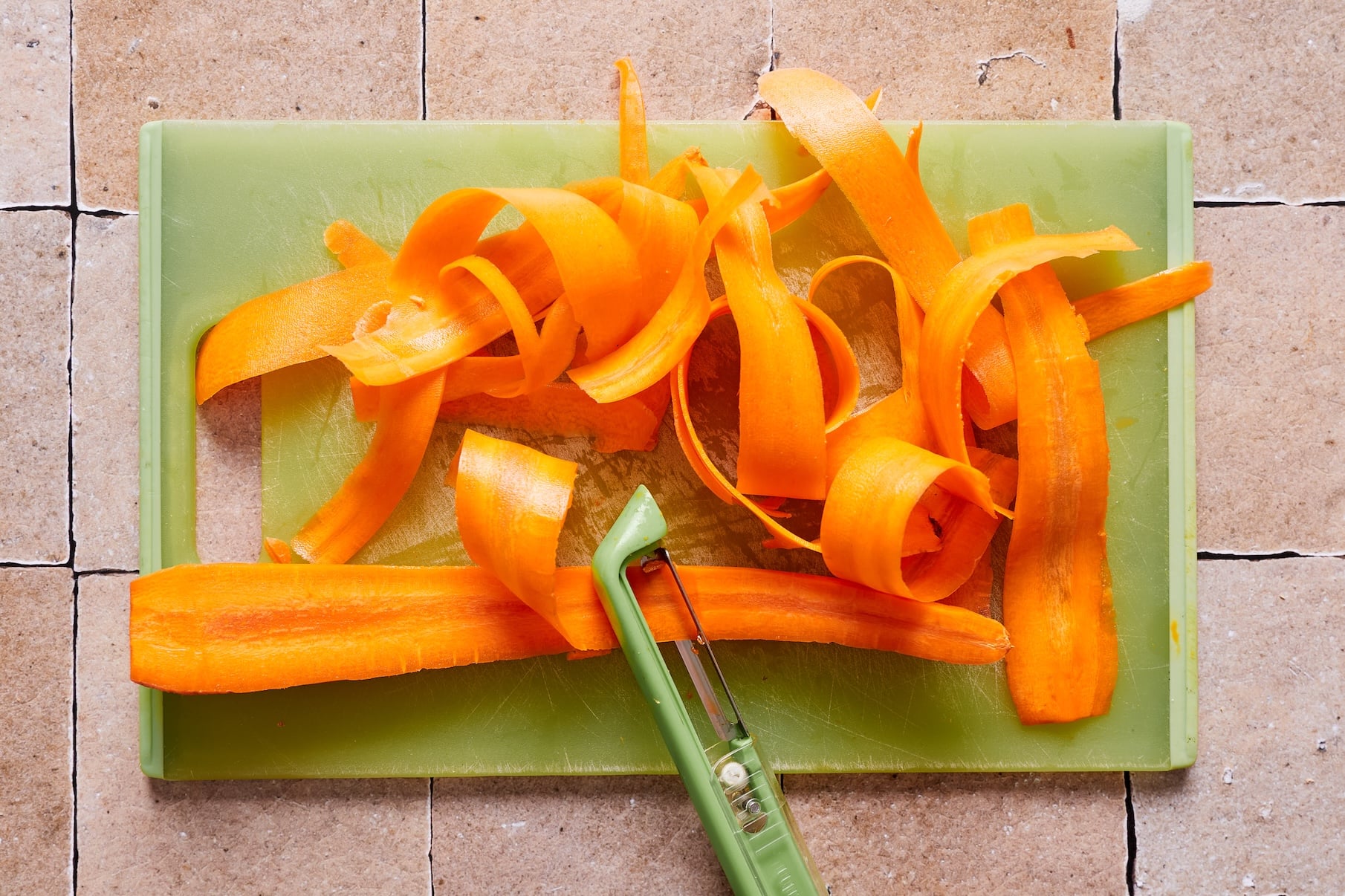 Using a vegetable slicer to cut carrots into ribbons