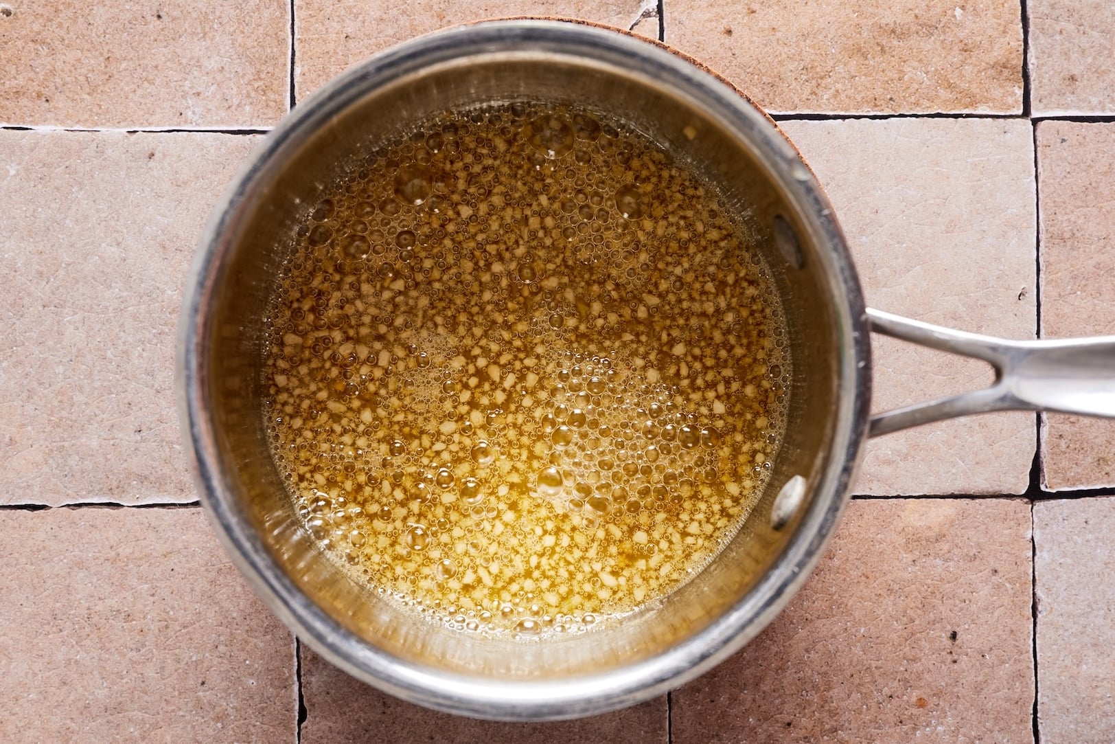 Making garlic oil by cooking garlic in olive oil and sesame oil briefly