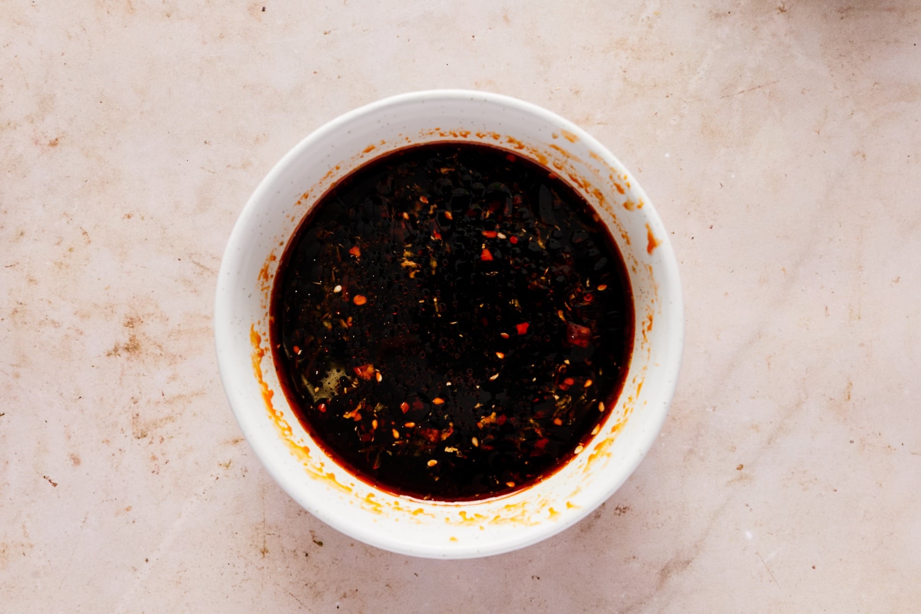 Honey garlic sauce ingredients whisked together in a small white bowl.